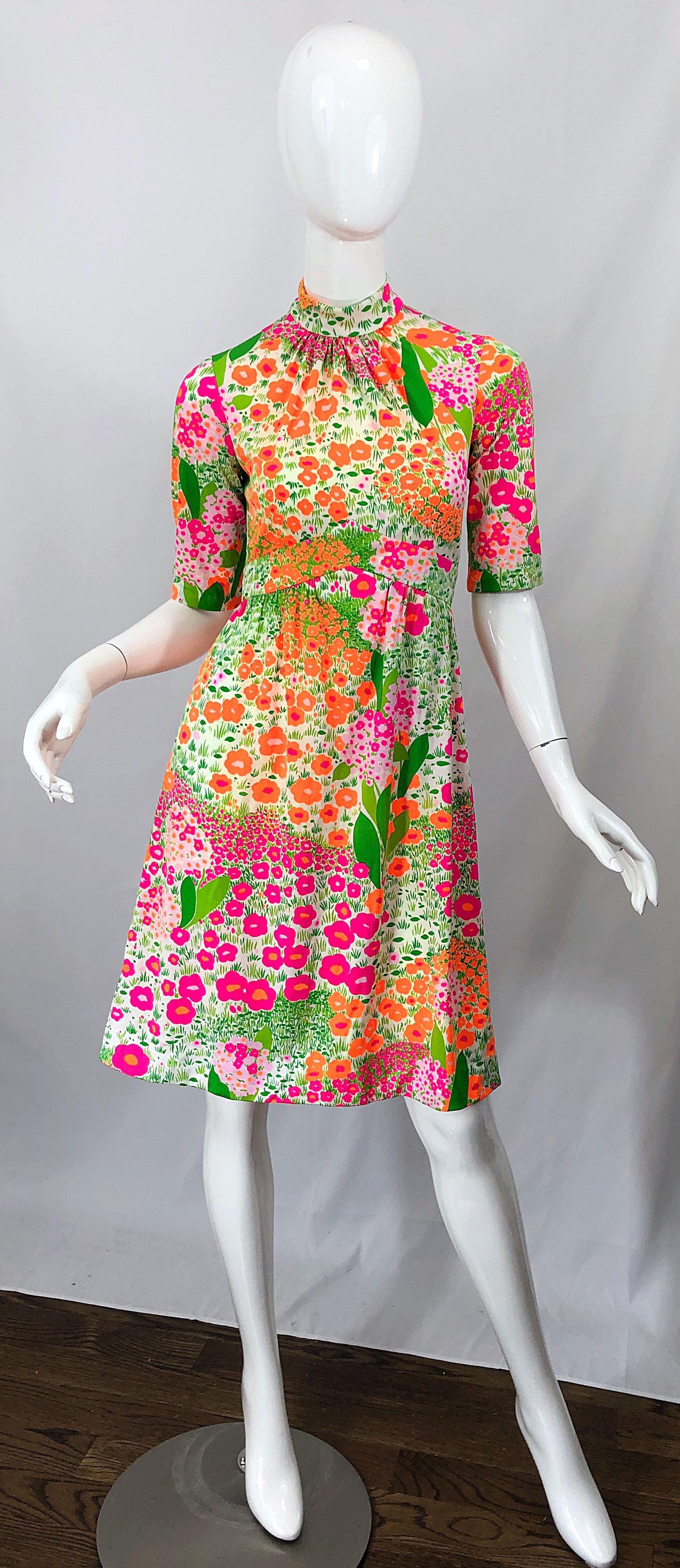 Chic late 1960s BONWIT TELLER bright colored high neck empire waist mod jersey dress! Features flowers printed in vibrant colors of pink, green, and orange throughout. Fitted bodice with short sleeves an a forgiving A Line skirt. Full metal zipper