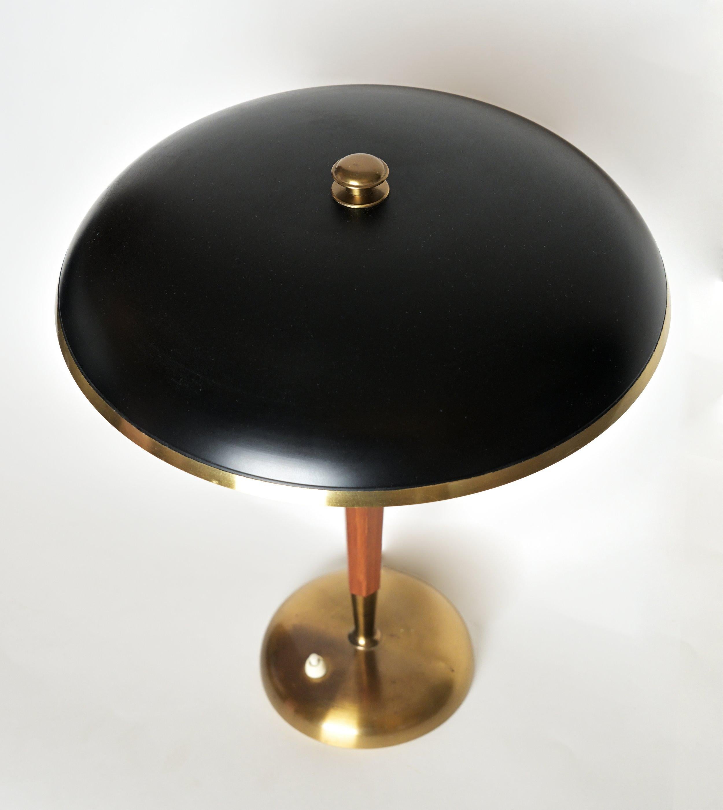 A 1960s Brass and Teak Desk Lamp, labeled Model number 8452, made by the Swedish Lighting company Borens, characterized by clean lines, exotic woods, soft edges and intuitive functionality, Having a teak and brass stem with a black brass shade