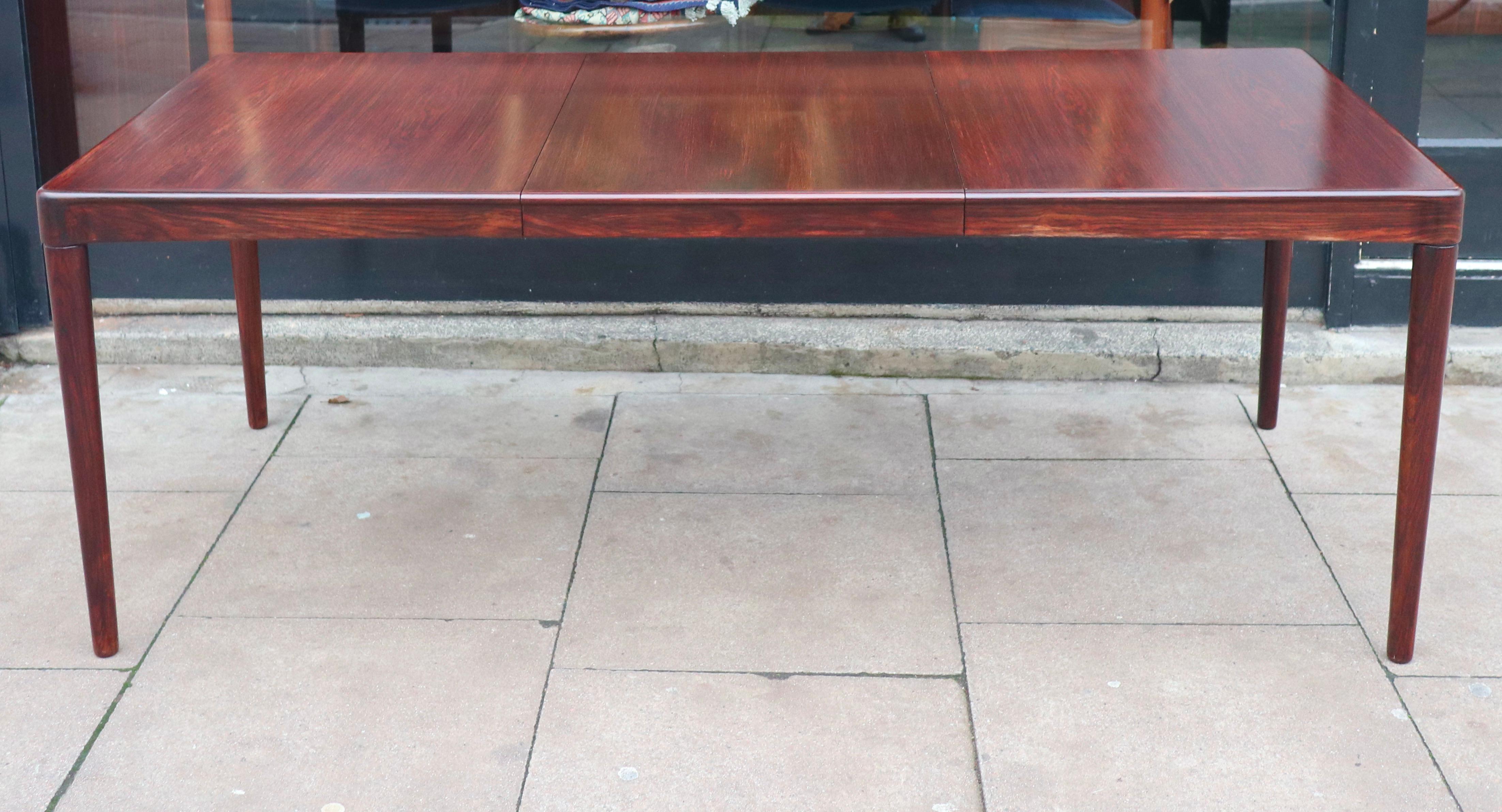 Très belle, rare et élégante table de salle à manger danoise des années 1970, rectangulaire, en palissandre, à rallonge, posée sur des pieds fuselés en palissandre massif. Cette table a été conçue par HW Klein et produite par Bramin. Elle comprend
