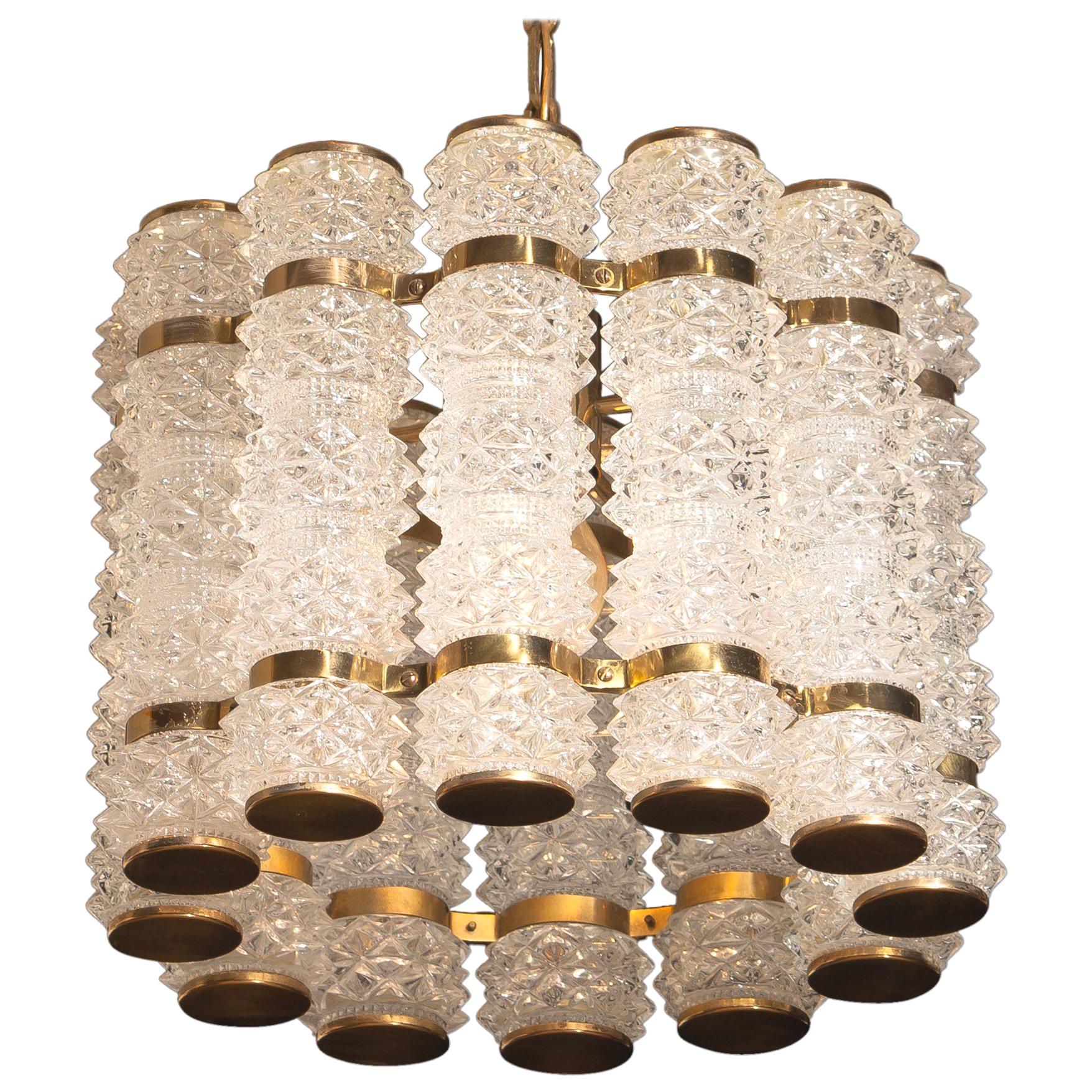 Beautiful and in perfect condition brass chandelier or pendant with twelve crystal cylinders.
Designed and manufactured in by Tyringe Konsthantverk, Sweden.
All crystal cylinders are made by Orrefors, Sweden.
Wired for 220 and 110 volts. Bulb