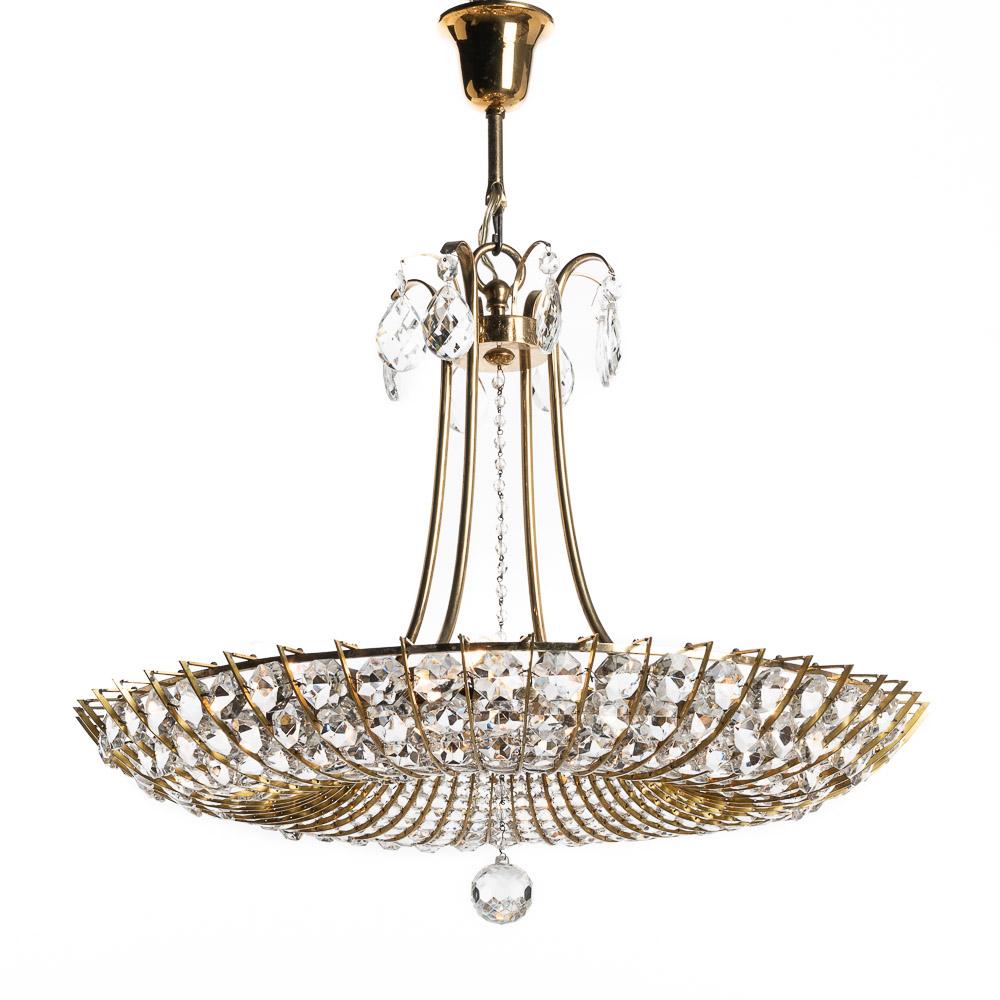 This is a wonderful design attributed attributed to Lobmeyr. Stunning crystal glass and patinated brass chandelier. The combination of these materials expertly crafted give this piece a real ritzy feel. Made in the 1960s, it’s still in beautiful
