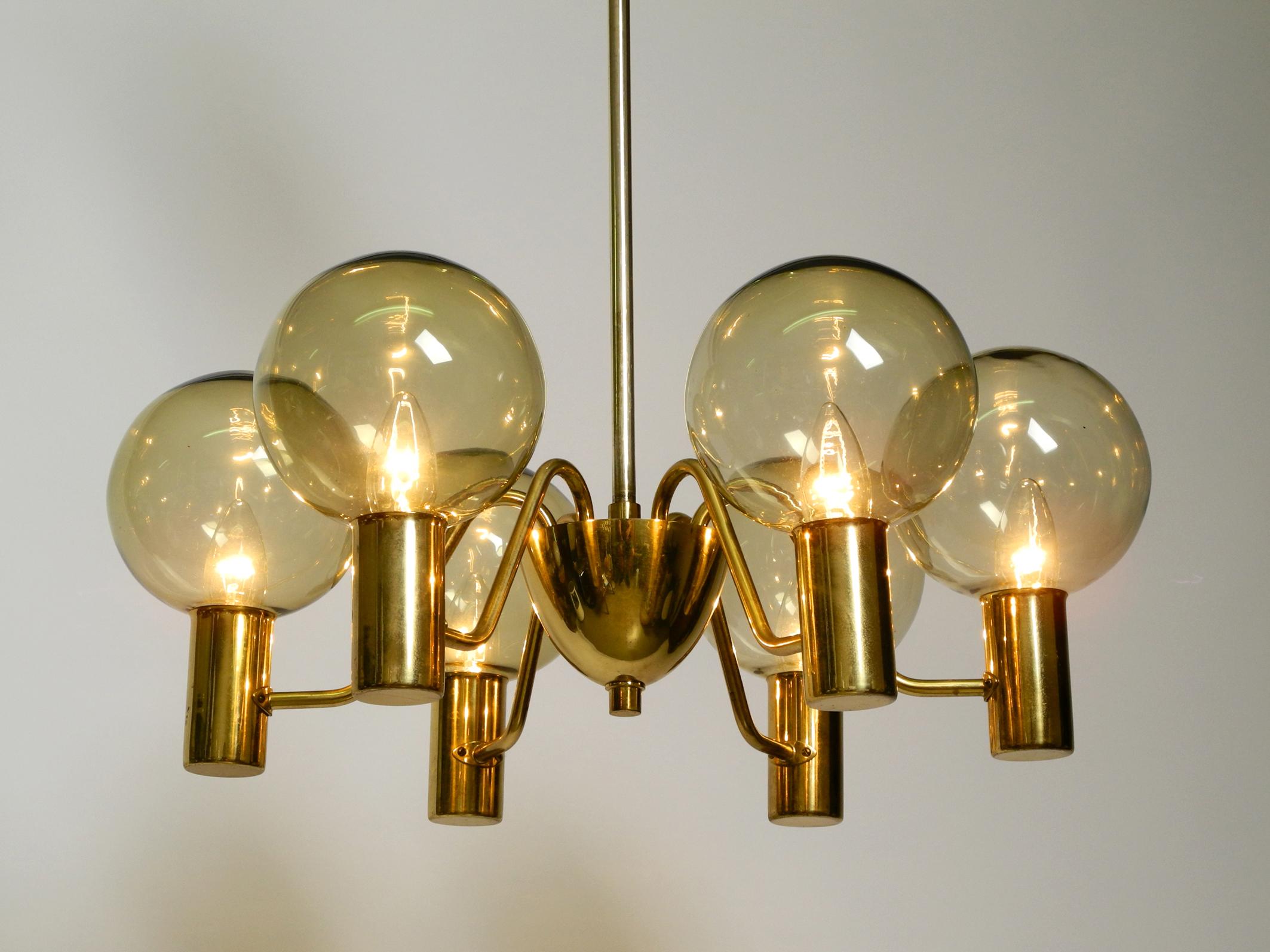 Beautiful 1960s brass ceiling lamp with 6 arms.
Design by Hans Agne Jakobsson Model T 372/6 'Patricia'
Manufacturer is Markaryd. Made in Sweden.
Glass globes in golden color. Entire lamp, canopy and rod are in polished brass.
Fantastically