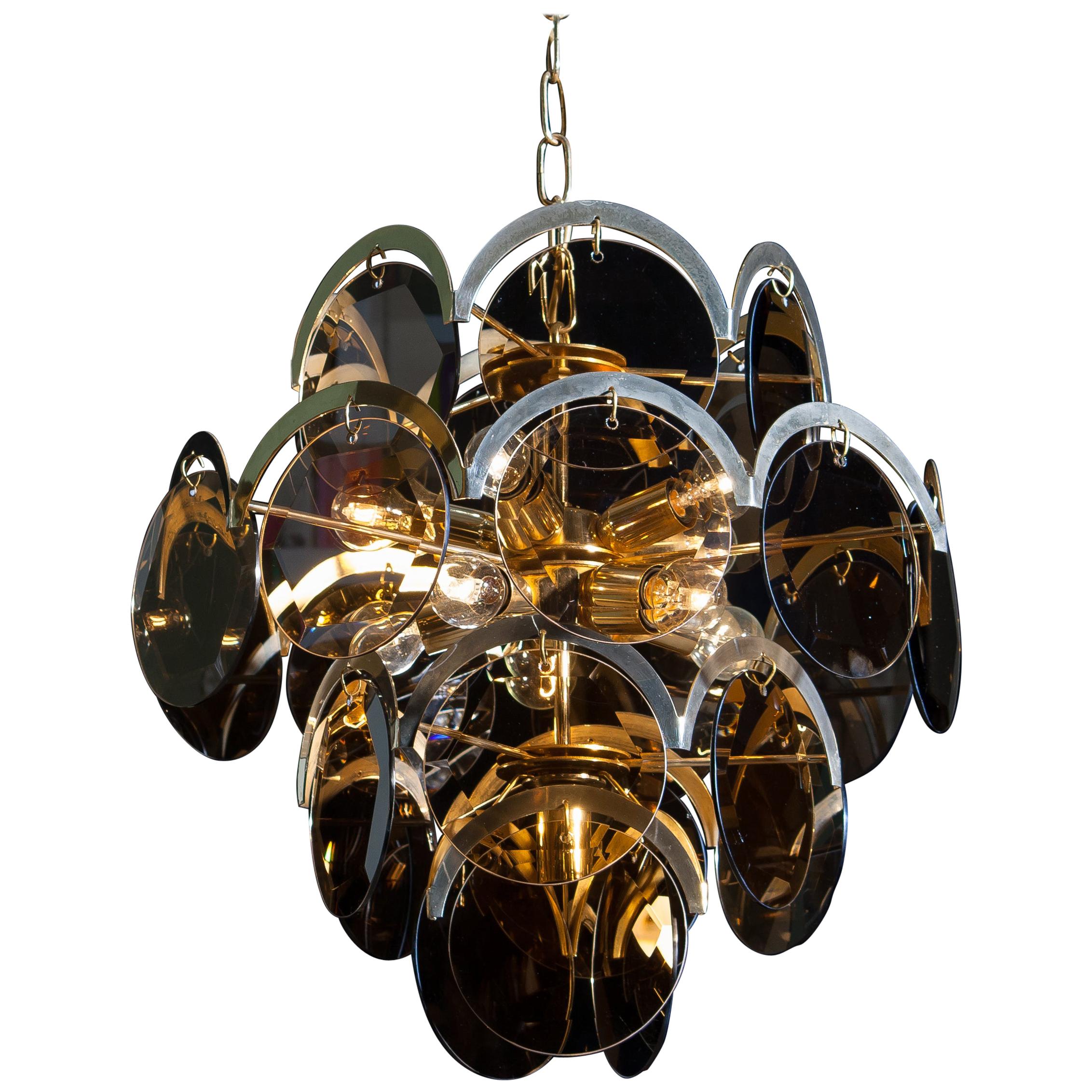 Beautiful chandelier in brass with twenty-four smoked (facet cut) hard glass discs by Gino Vistosi.
The chandelier is in good condition and contains ten fittings, size E14 /17.
Technically 100%.