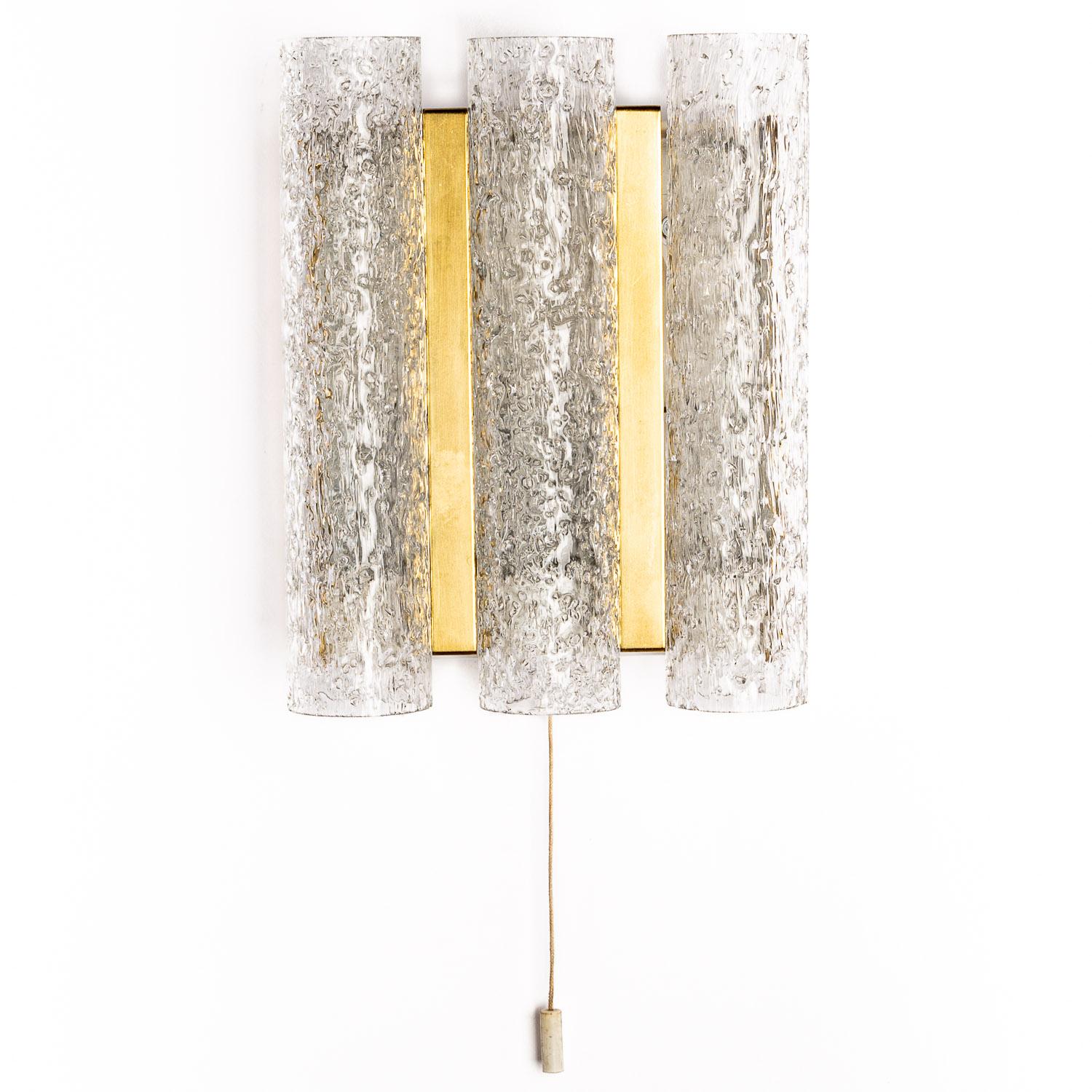 If you like vintage lighting then you will love this Doria glass sconces. Designed with three vertical tubes astride brass plates and metal centre, it's a highly distinctive piece and looks stunning when illuminated. Authenticity is guaranteed with