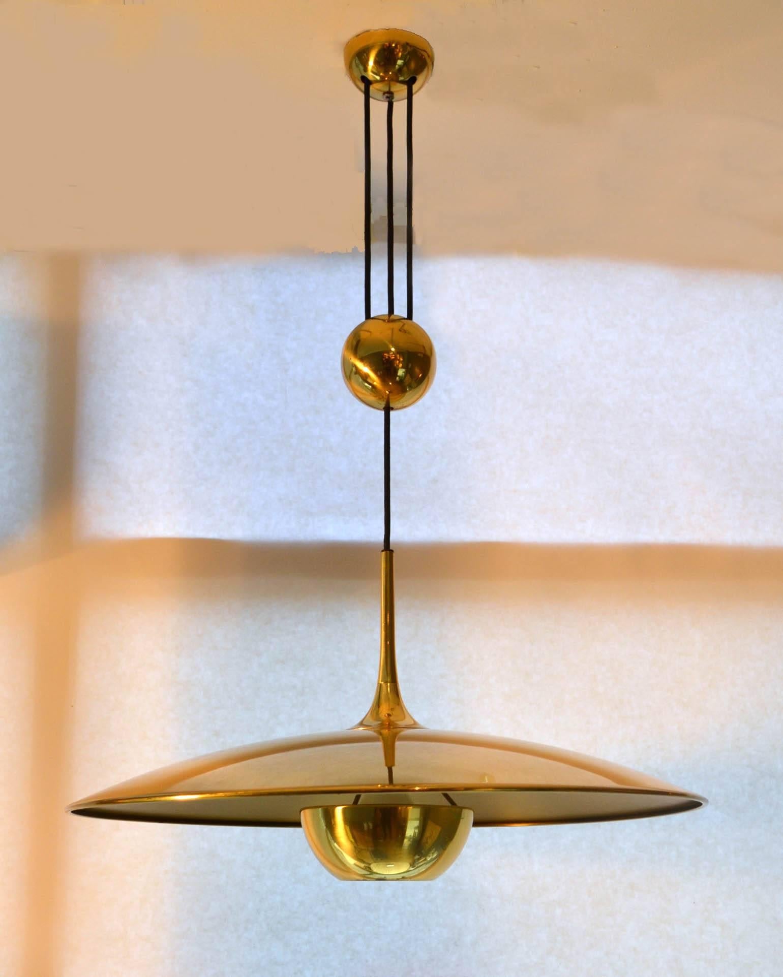 Early counterbalance pendant Onos 55 by Florian Schulz. This elegant and minimal pendant in a high quality brass moves smoothly up and down due to the solid brass counterweight. The shade was a brass diffuser. 
Excellent timeless design of a very