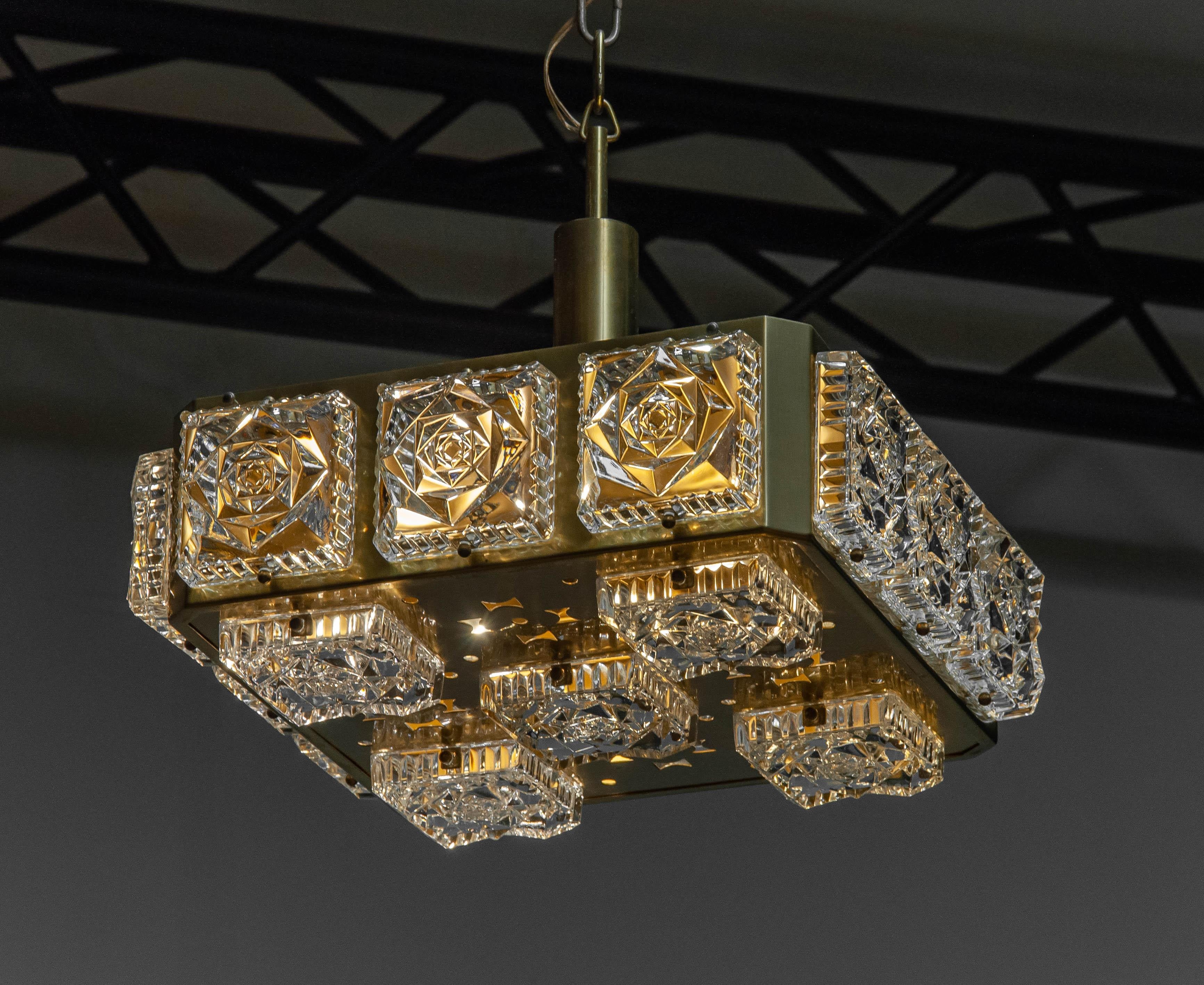 Bellissima lampada da soffitto quadrata degli anni '60 in ottone con diciassette grandi elementi quadrati in vetro artistico pressato della manifattura svedese Boréns Borås. 
La lampada è tecnicamente al 100% ed è composta da quattro attacchi a vite