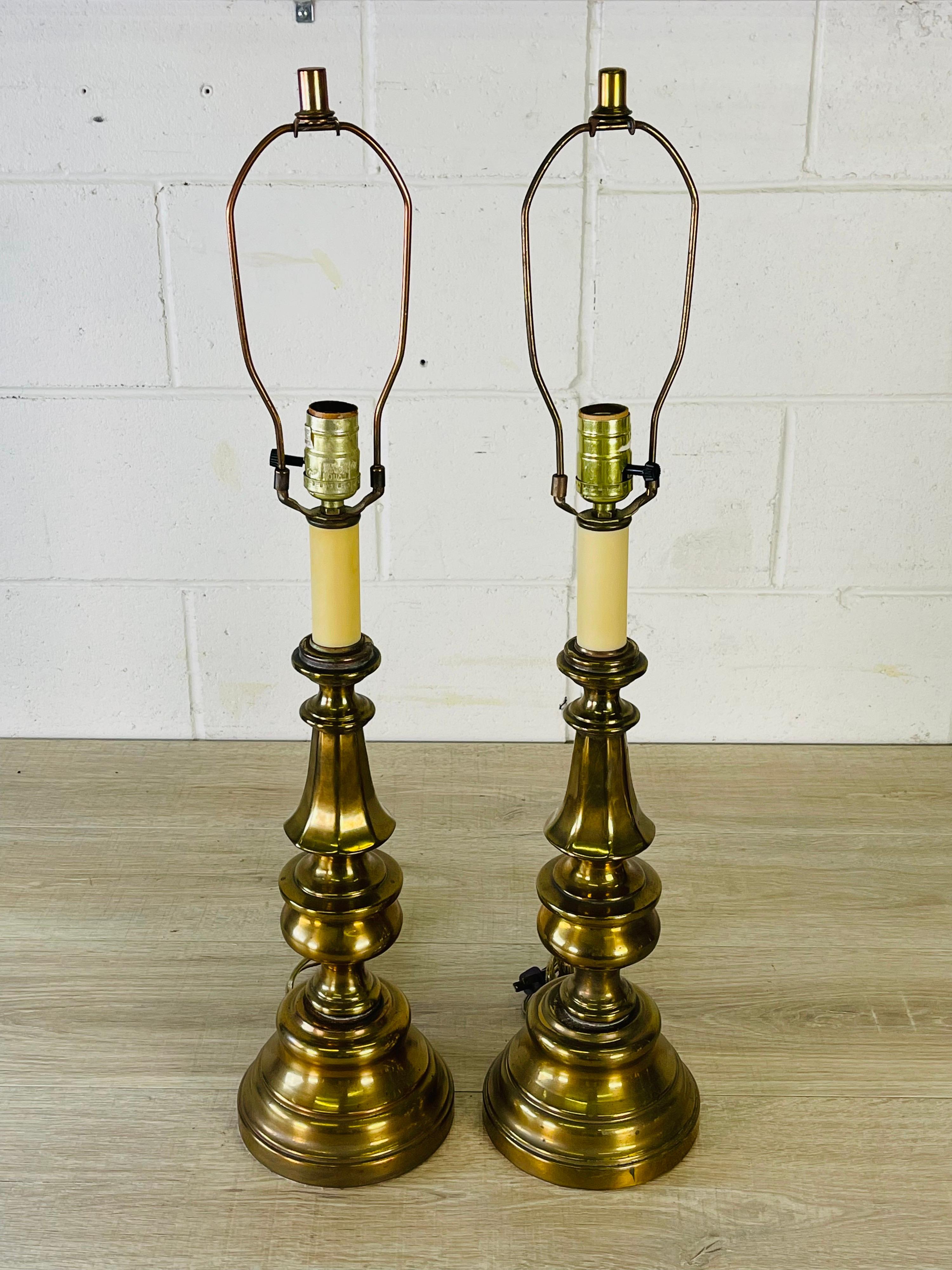 Vintage 1960s pair of brass table lamps. The lamps are wired for the US and in working condition. Uses standard 100 watt bulb. Socket, 21.5”H. Harp, 4”Dia x 8”H. New wiring. No marks.