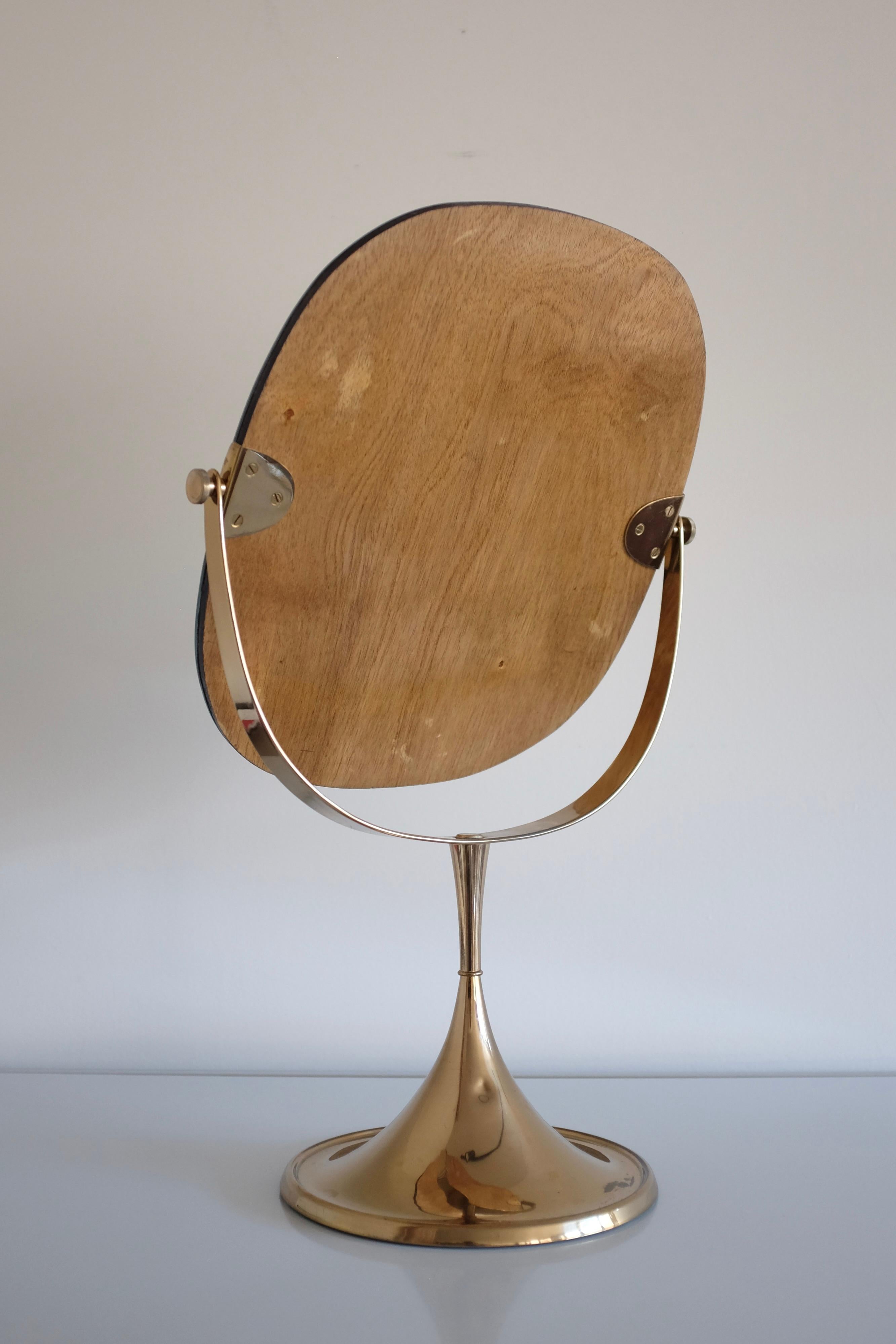 Impressive 1960s Brass table mirror by Bergbom from the B-024 series. The trumpet shaped base have 2 arms that holds the mirror. The angle of the mirror can be adjusted by side screws on each arm and the mirror rotate. In the same collection from