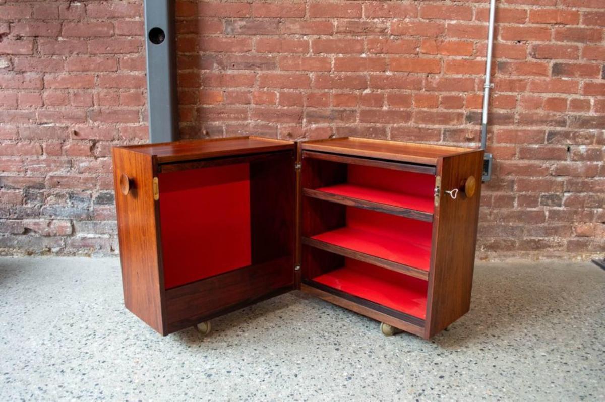 We are excited to offer this charming little cabinet that folds open to expose shelving for glasses, bottles, etc and that has two little trays that can be removed and used on top of the piece when desired. The rosewood exterior is freshly restored