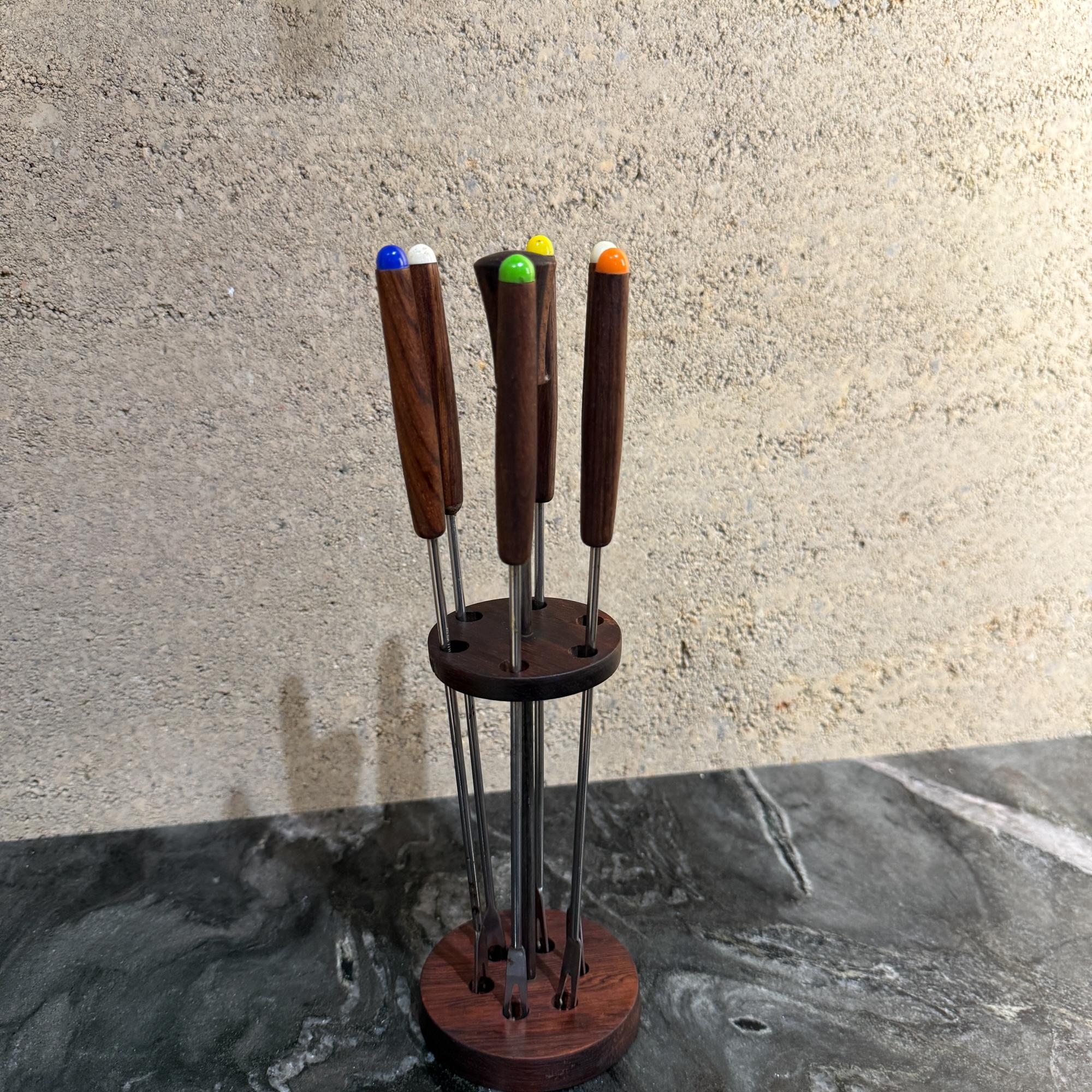 Für Ihre Überlegung, ein Vintage-Set von Fondue-Gabeln mit einem hölzernen Stand (brasilianisches Rosenholz). Das Set umfasst in der Regel Edelstahlgabeln mit farbcodierten, hitzebeständigen Griffen, so dass jeder Gast seine eigene Gabel während der