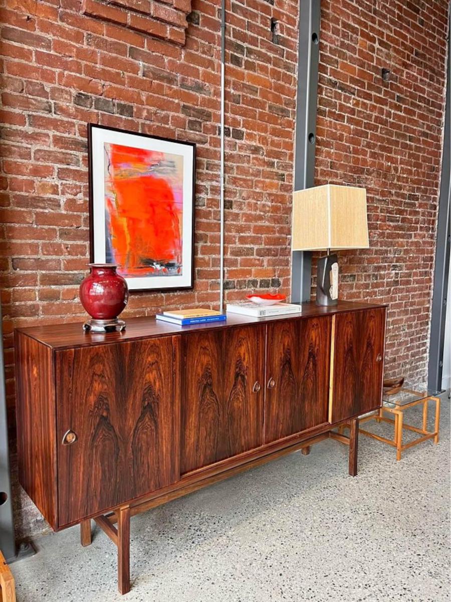 We're excited to introduce our newest addition: a stunning vintage Danish case piece, meticulously restored in our workshop. Crafted in the 1960s from exquisite Brazilian rosewood, its mesmerizing grain exudes charm. With a sturdy base, adjustable