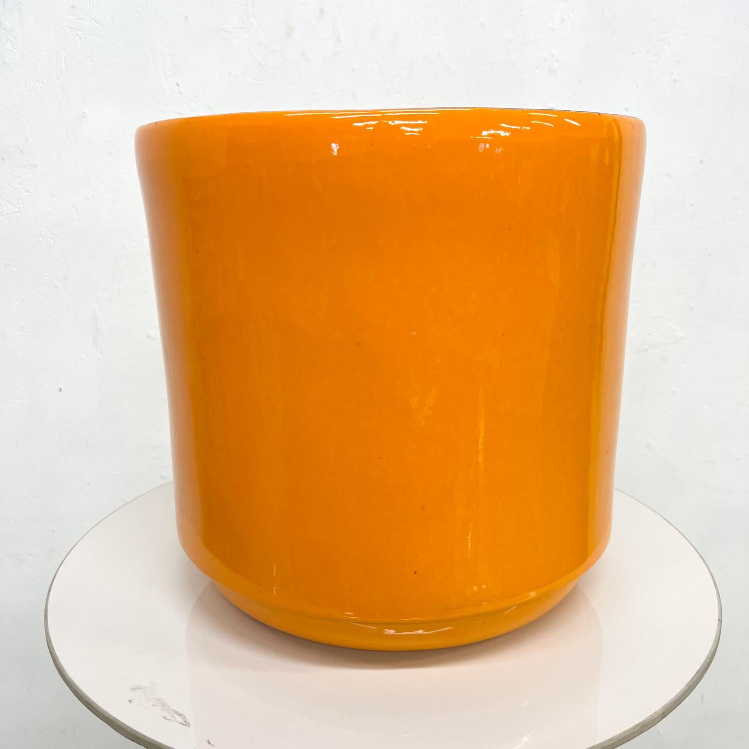 1960s Modern Gainey Style Pottery Orange Planter 
Glaze exterior black flat interior
15 tall x 15.5 diameter
Stamped at bottom.
Made in the USA.
Preowned original vintage condition. Minor nicks on finish present.
Refer to images. 
