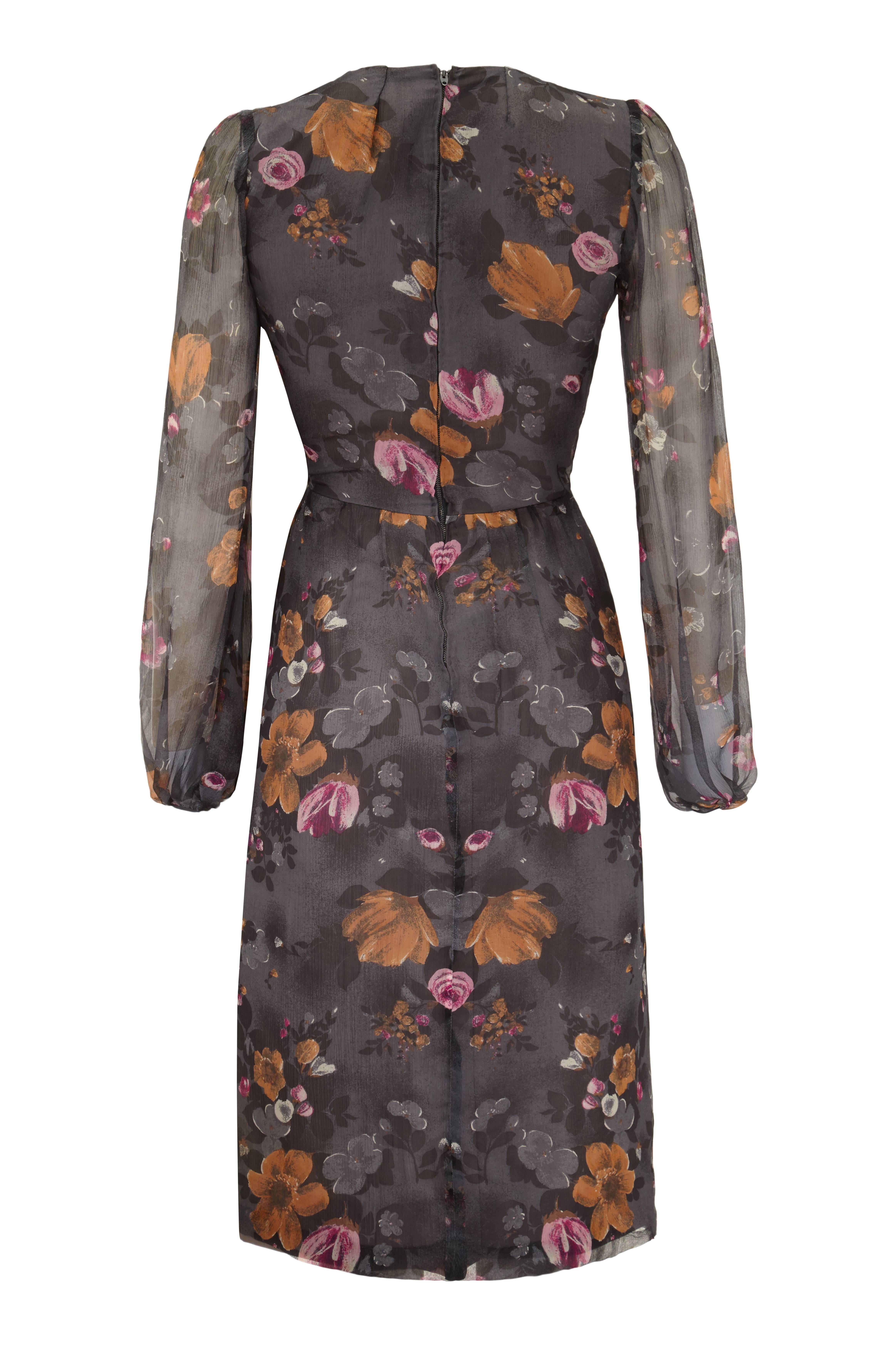 Cette jolie robe de couture vintage des années 1960 en mousseline de soie grise présente un imprimé floral discret en rose fuchsia, ocre foncé et charbon de bois. Elle est en excellent état vintage. Il n'y a pas d'étiquette, mais nous sommes en