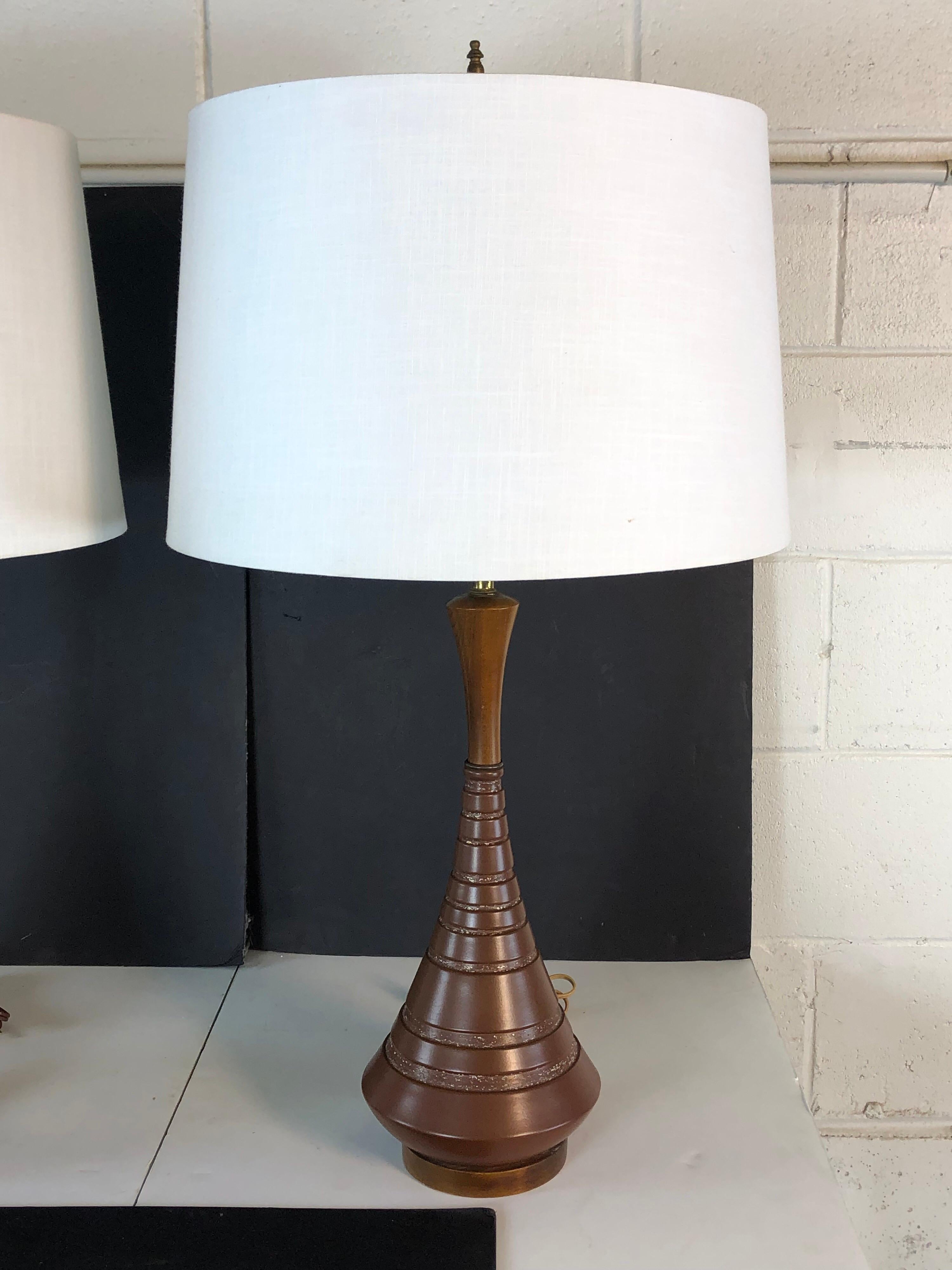 1960s pair of striped brown ceramic and walnut wood table lamps. The lamps are wired for the US and in working condition. Socket, 21.5”H. Harp, 4.5”Dia x 10”H. The shades are not included.
