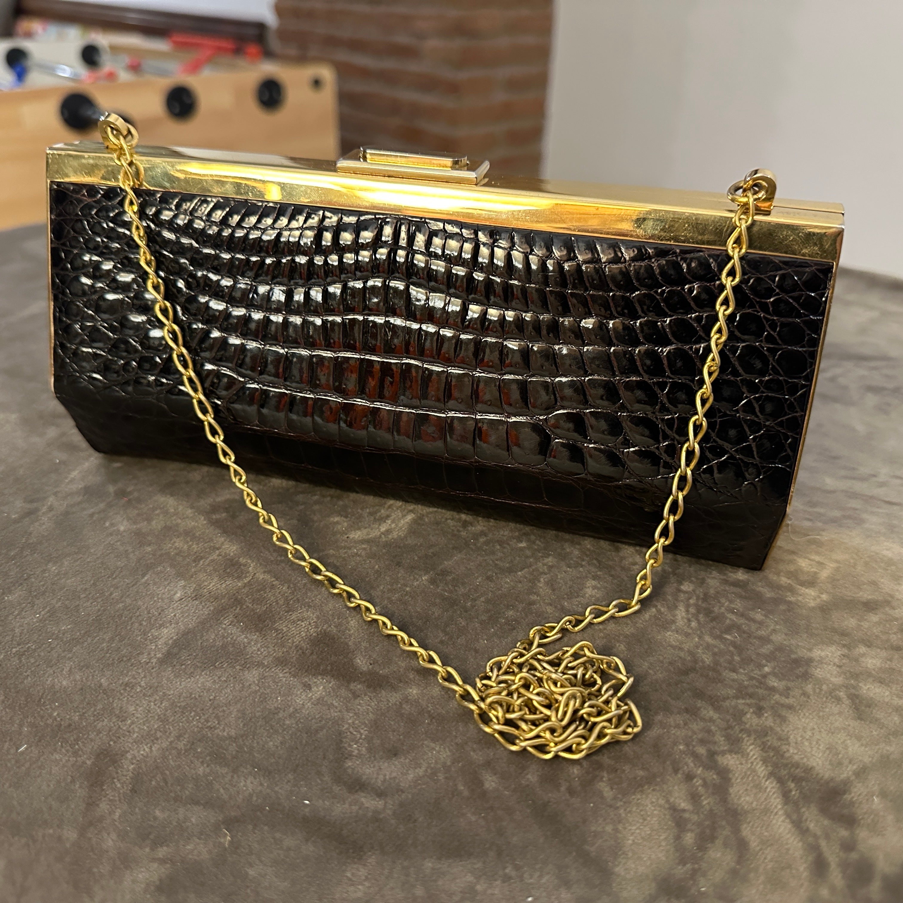 This is a vintage Italian handbag that showcases an elegant and timeless design. It features a structured, rectangular front shape and an irregular hexagonal side shape with rich brown crocodile-embossed leather, giving it a luxurious and textured