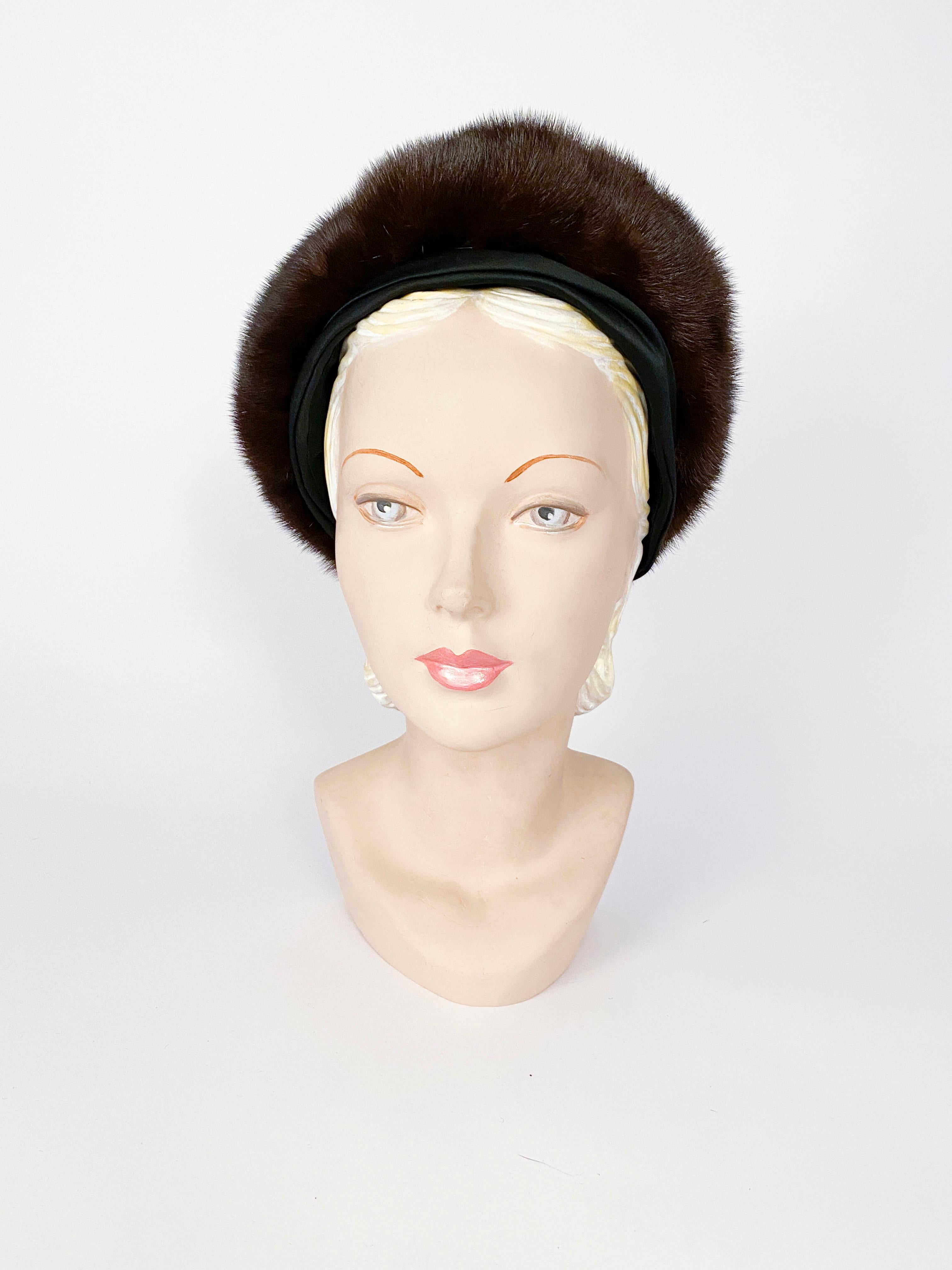 1960s brown ranch mink structured hat with a band of silk satin. The inside is lined with starched lace to give this hat a tall shape.