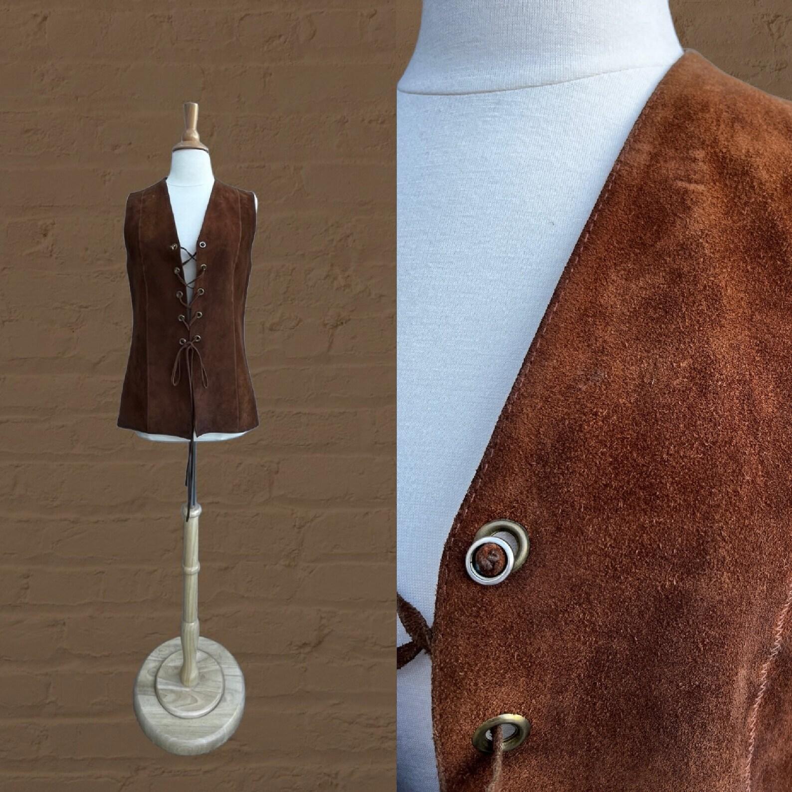 vintage brown suede vest
grommets along center front
lace up closure
top stitching
vest is unlined

Circa 1960s 
Susan Small
Made in England
Brown
100% Suede
Excellent Condition. ✩ Dry Cleaned.

✂----M e a s u r e m e n t s: all in inches.

Bust
