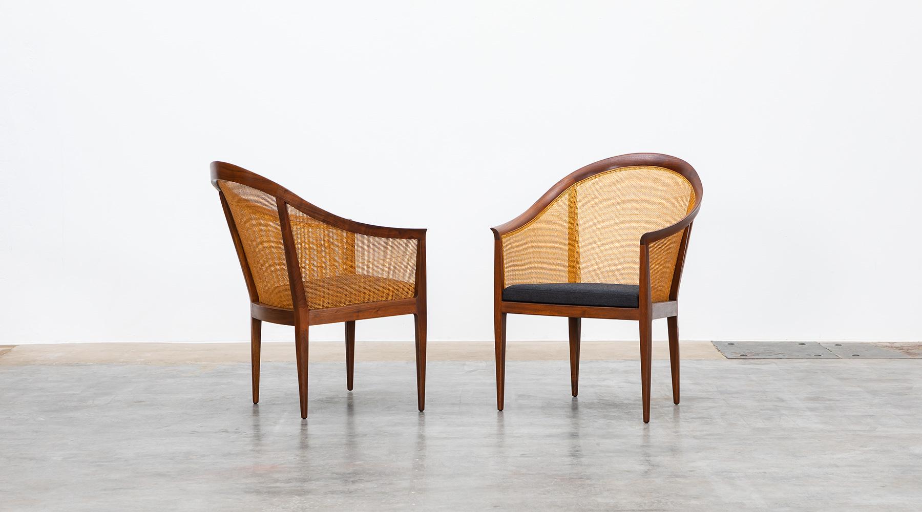 Lounge chairs, walnut and cane, new upholstery, Kipp Stewart, USA, 1960s.

Elegant pair of armchairs in solid walnut with caned back and sides designed by Kipp Stewart. The caning and wood are in excellent condition. The seat cushions are new