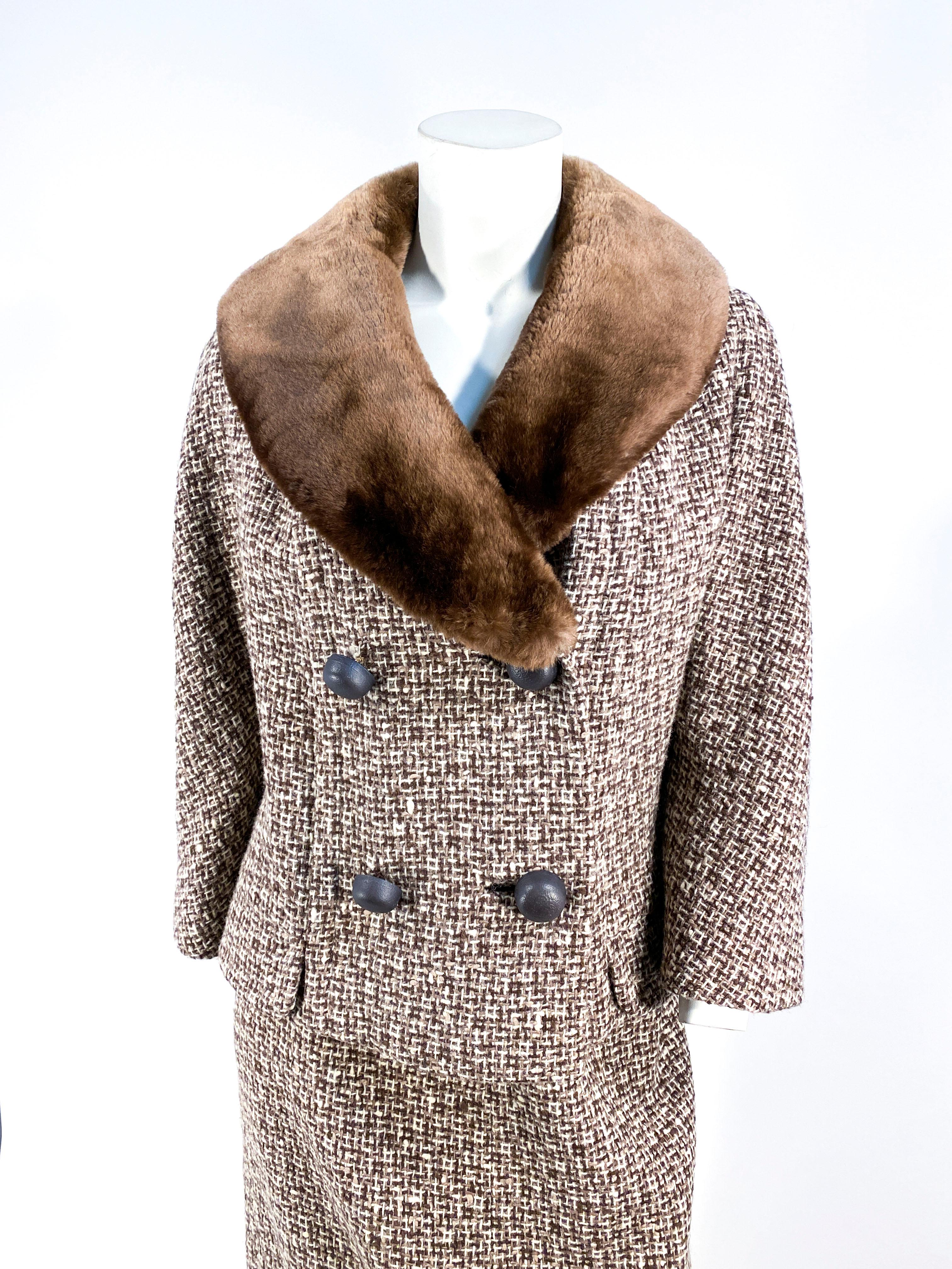 1960s tweed wool suit featuring a weave in multi tones of brown, cream, and chocolate. The double breasted jacket of the suit has a cocoa brown sheared mink shawl collar that is plush and luxurious to the touch. In addition, the face of the jacket