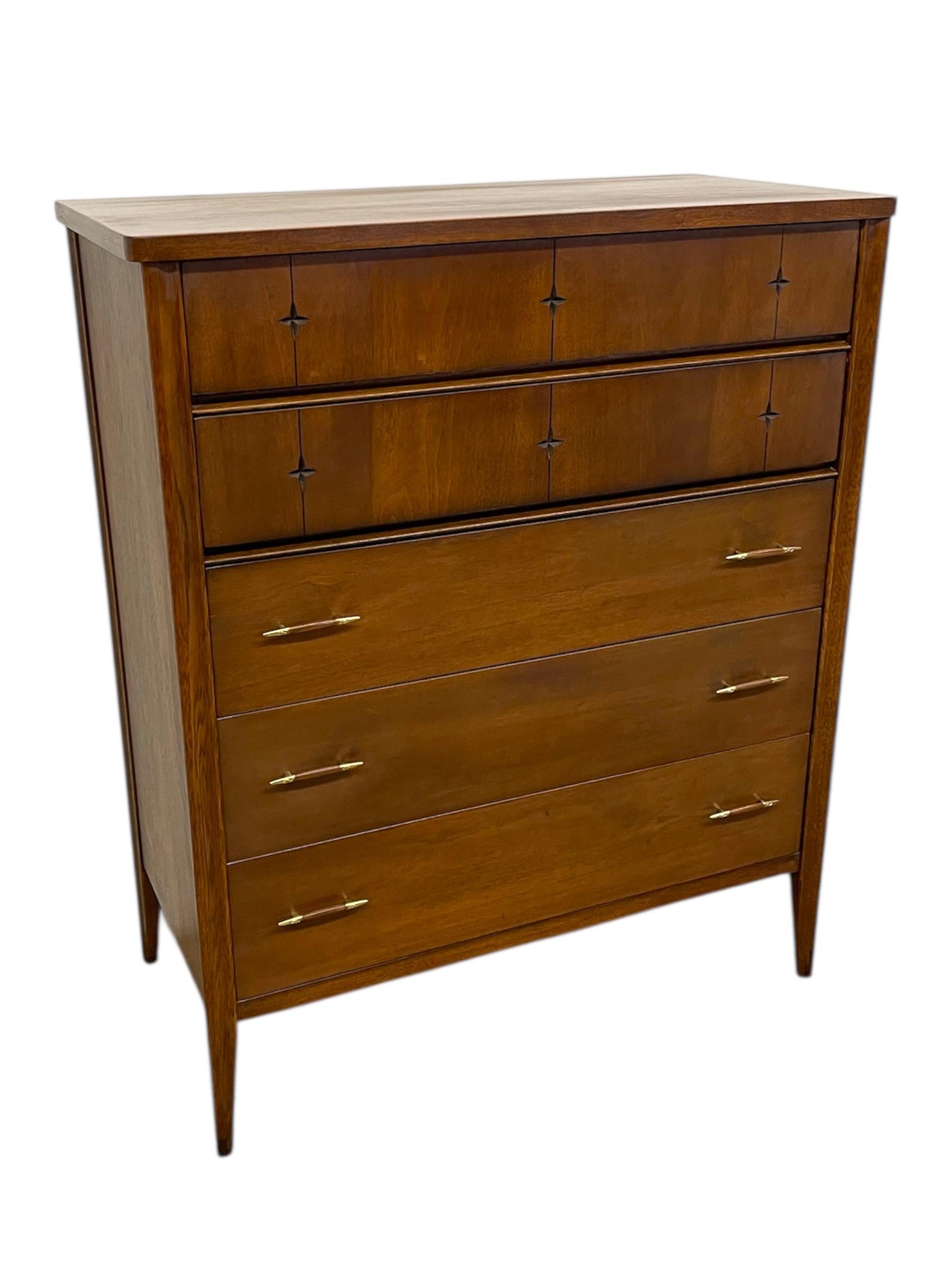 Nous proposons ici une commode haute originale Broyhill Premier Saga des années 1960, une pièce emblématique de l'une des lignes de mobilier américain moderne du milieu du siècle les plus reconnaissables. Fabriquée dans des tons de bois chauds,