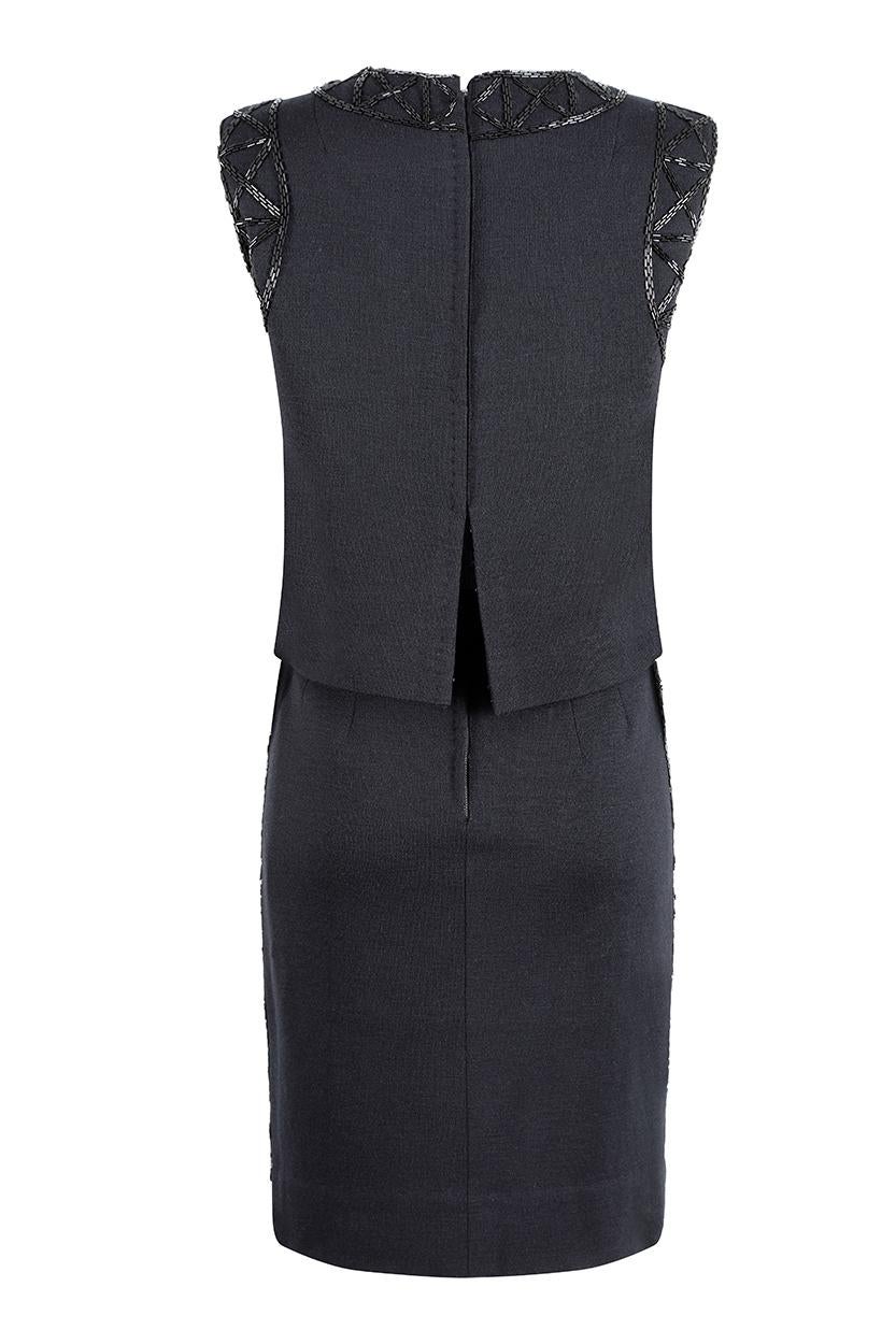 This chic 1960s black wool jersey cocktail dress is by Bruce Arnold Boutique, Hong Kong and is of exceptional quality and workmanship. Designed to appear as separates, the bodice of the dress is overlain so that the fabric surpasses the waistline,