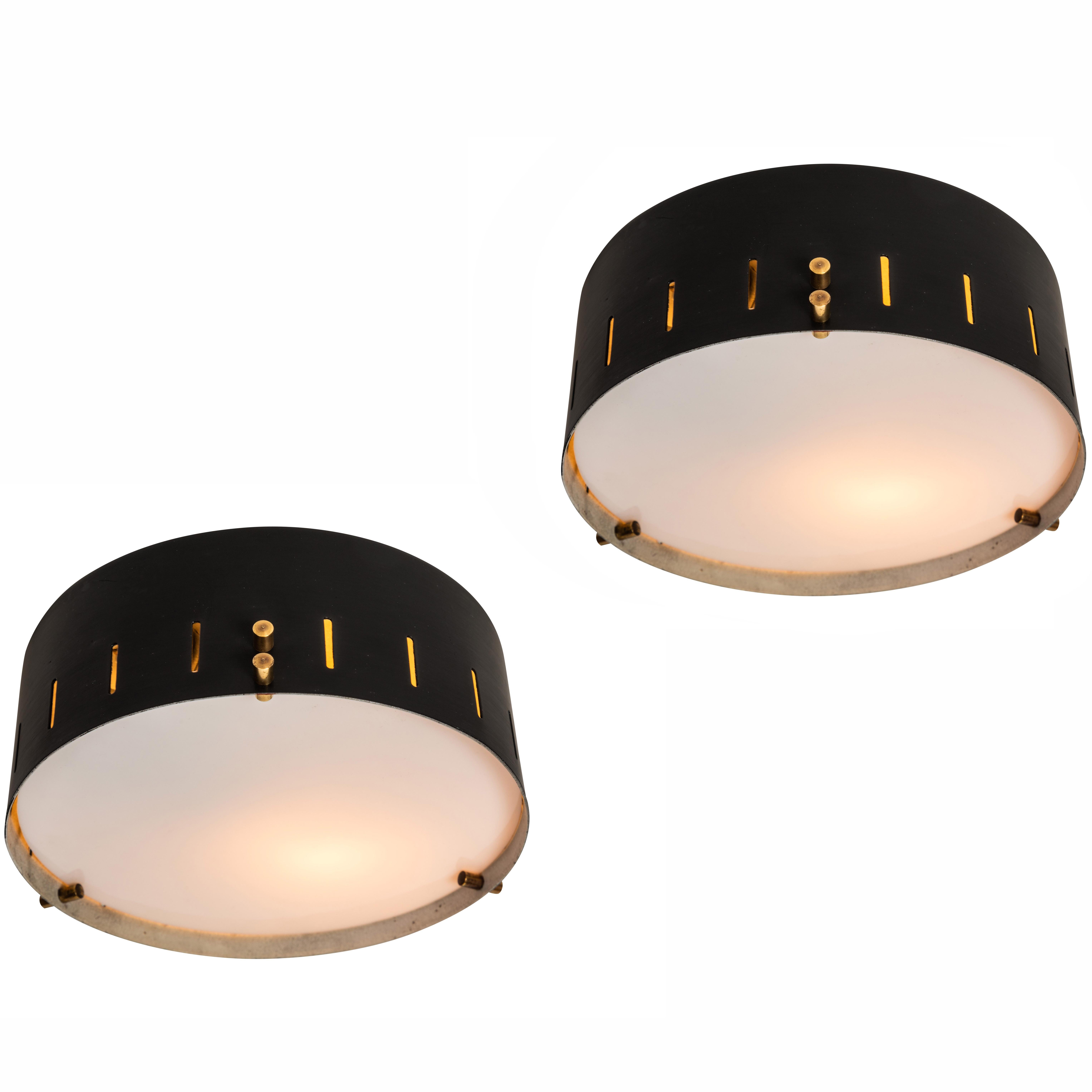 1960s Bruno Gatta wall or ceiling light for Stilnovo. Executed in black painted metal with opaline glass and brass hardware. A sculptural and refined design characteristic of 1960s Italian design at its highest level.

Price is per item.