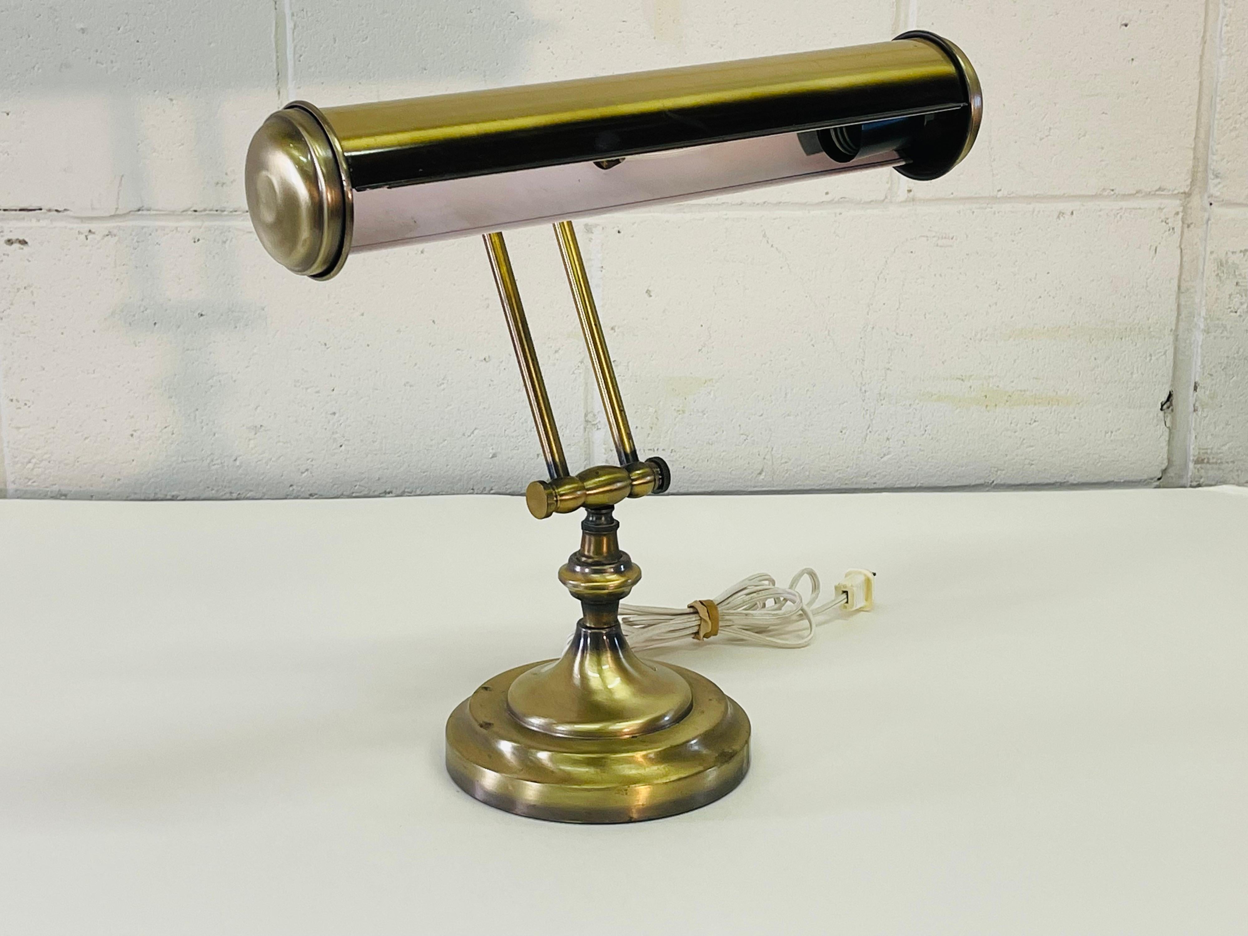 Vintage 1970s brushed brass adjustable desk lamp. The lamp is wired for the US and in working condition. Uses a cylindrical light bulb. Adjusts in two spots. Light tarnish from age. No marks.
