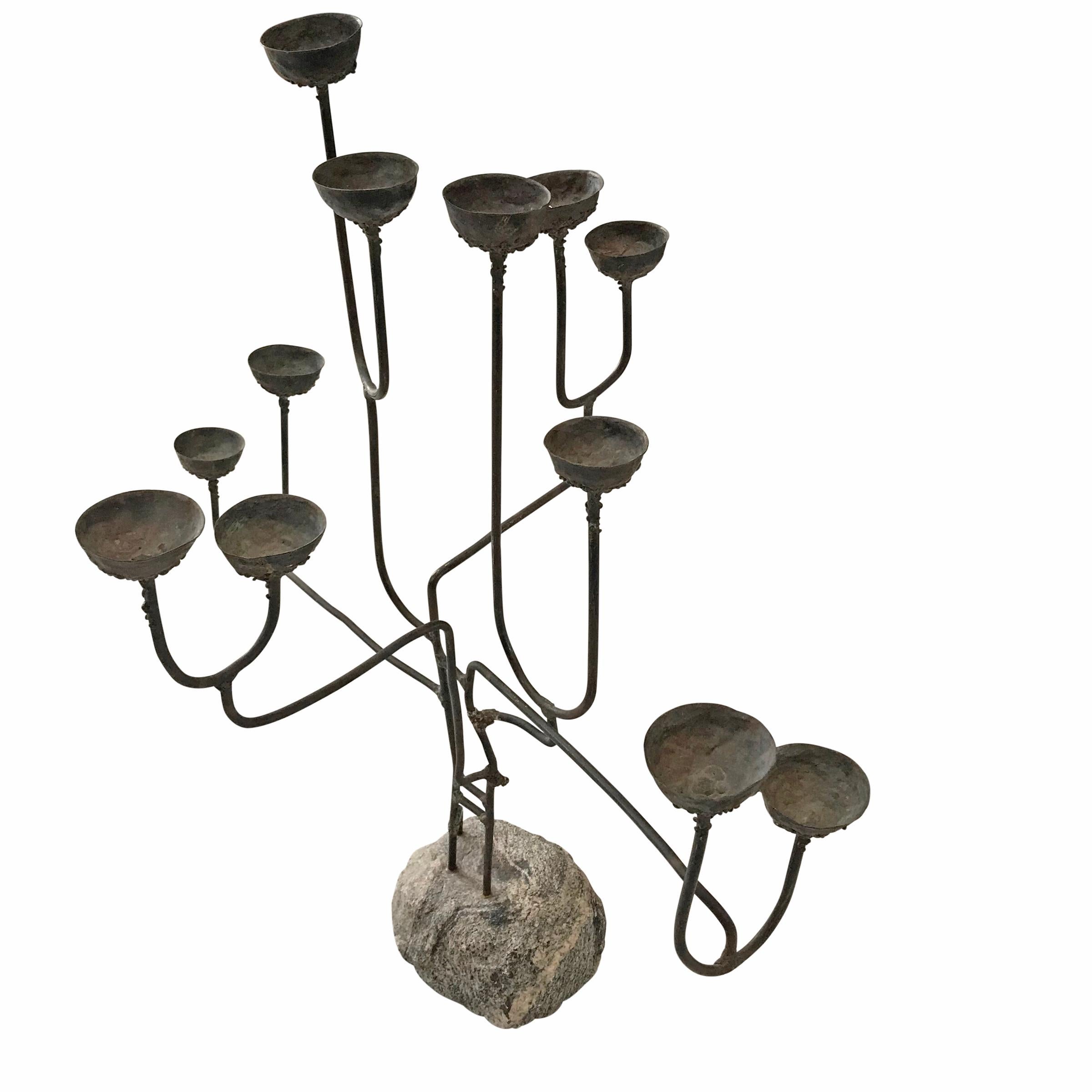 An incredible mid-20th century American Brutalist bronze twelve-arm candelabra with applied bronze drips surrounding the cups, and anchored with a granite bolder.