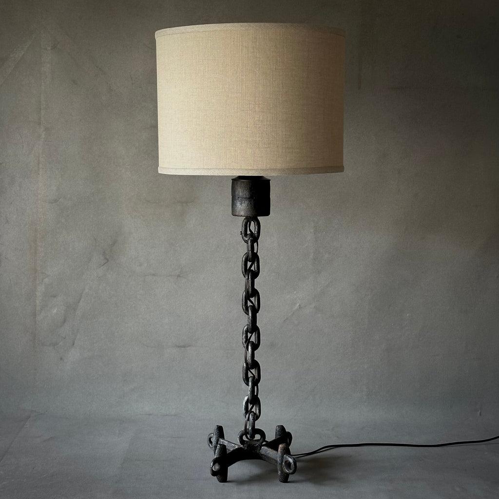 Midcentury Dutch table lamp with black chainlink base and mounted on an Industrial style four-footed trivet. Includes contemporary custom Belgian linen drum shade. Edgy yet graceful, with a strong Brutalist feel. 

Netherlands, circa