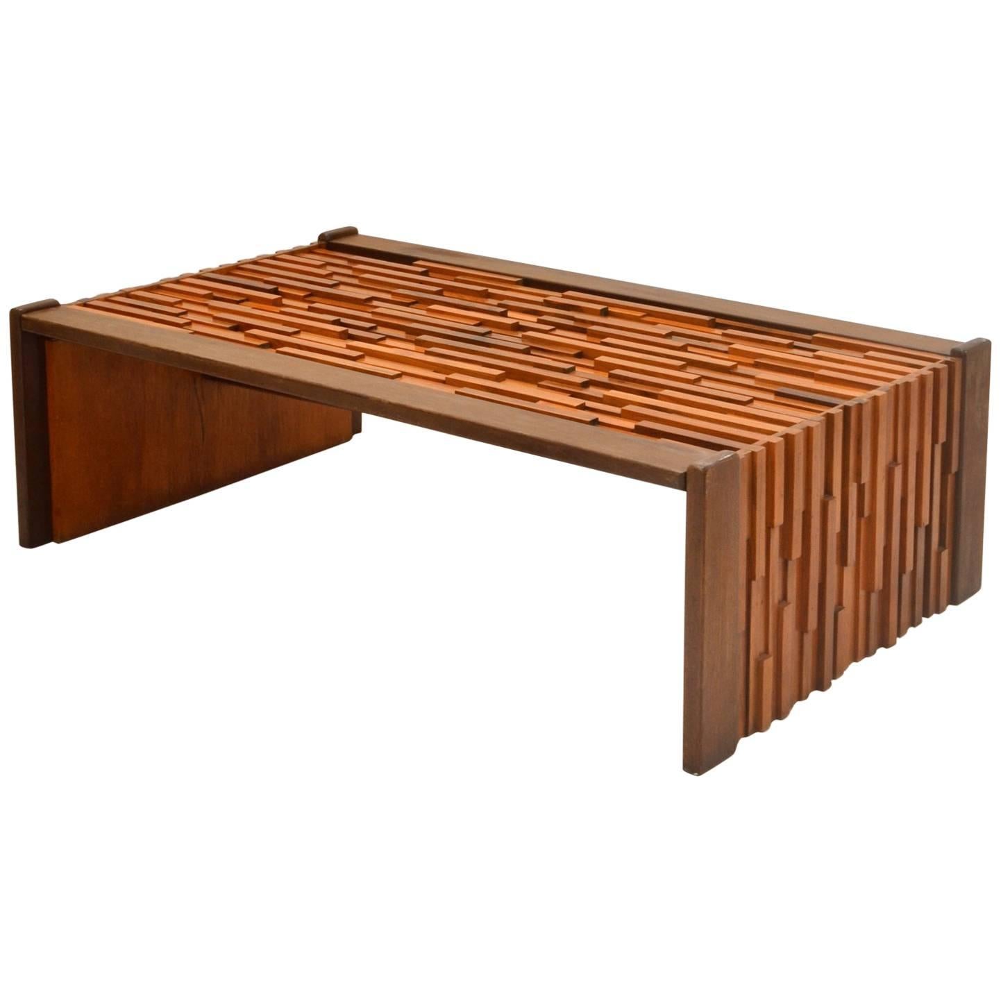 Brazilian coffee table designed as a sculptural relief of various tropical hardwoods in different heights and lengths to create a Brutalist effect edged with mahogany and fitted glass top. The table is made in Brazil by Percival Lafer. Table and