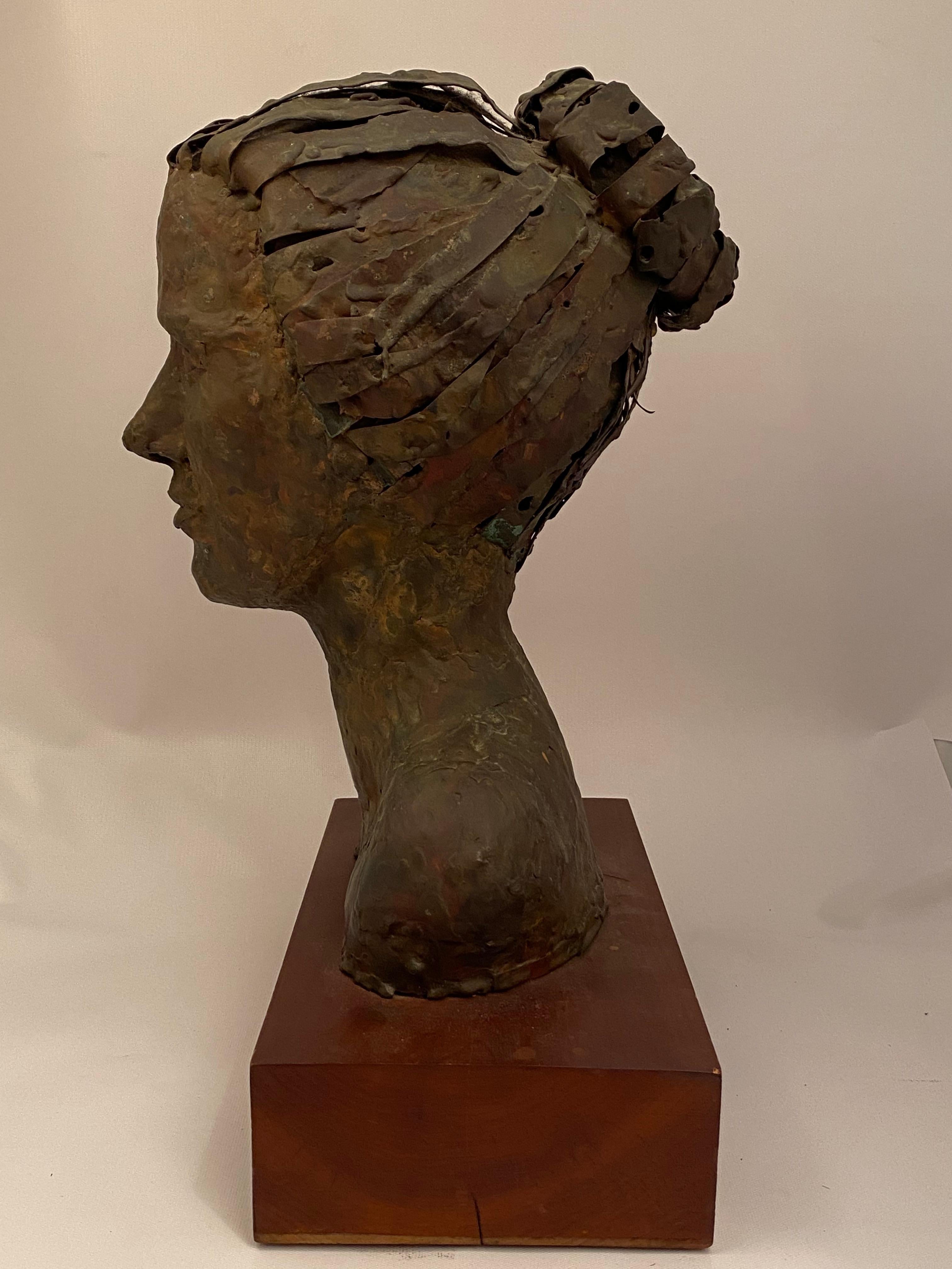 A wonderful copper portrait bust sculpture resting on a walnut base. Signed on the underside of base, R. Kennedy, 1961. Good overall condition. Wear commensurate with age and use. Overall dark patina and some verdi gris oxidation. Measures: