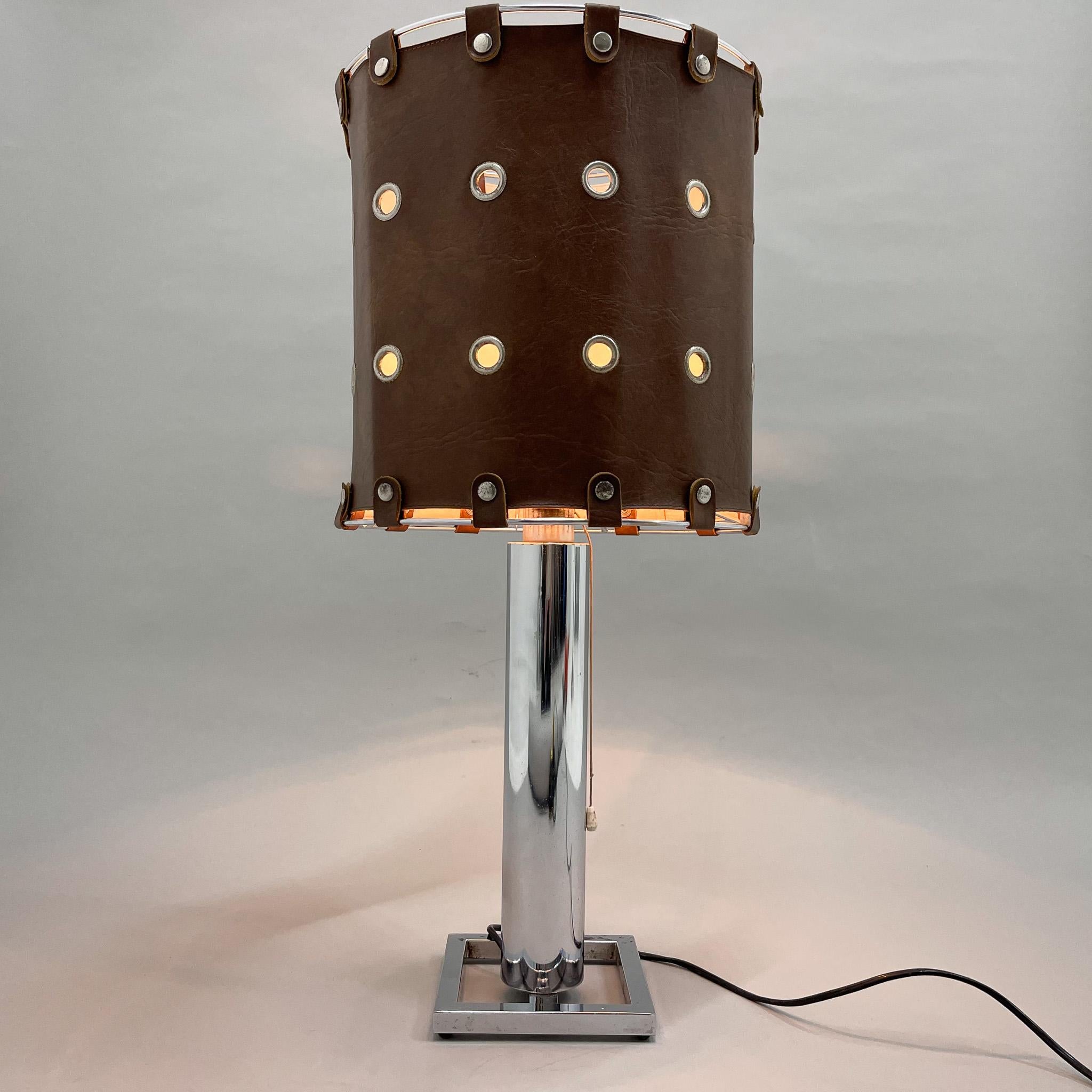 Une lampe de table très inhabituelle composée d'une base chromée et d'un abat-jour en cuir véritable. Fabriqué en Italie dans les années 1950. En bon état vintage avec quelques signes d'usure, voir photo. 
Ampoule : 1 x E25-E27.