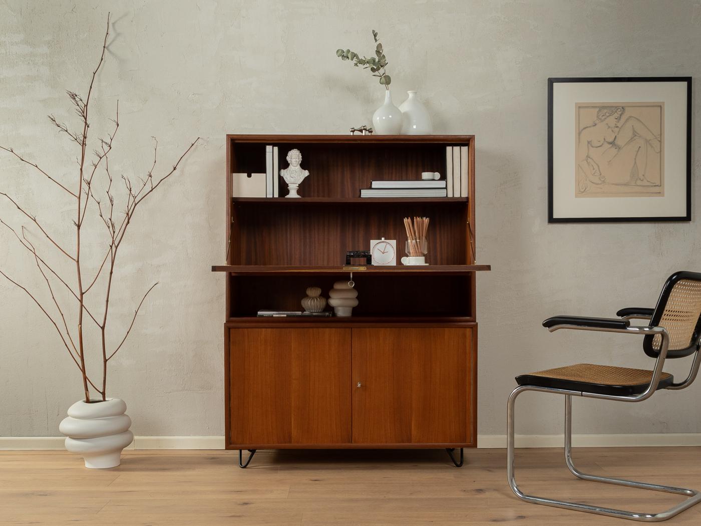 Buró clásico en dos partes de los años 60. Corpus de alta calidad en chapa de teca con encimera abatible, dos puertas, dos estantes, un compartimento para libros y patas de horquilla nuevas en negro.

- Muy buena mano de obra
- Materiales de alta