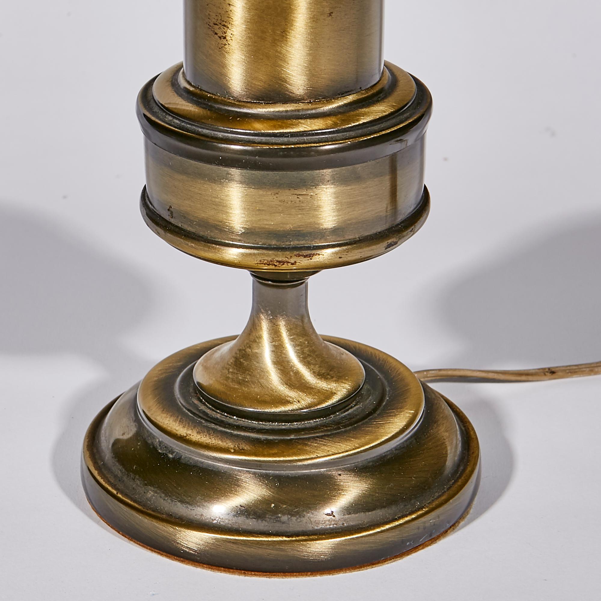 1960s burnished brass table or desk lamp. The lamp has a metal shade. Wired for the US and in working condition. Uses two standard bulbs. No maker's mark.
   