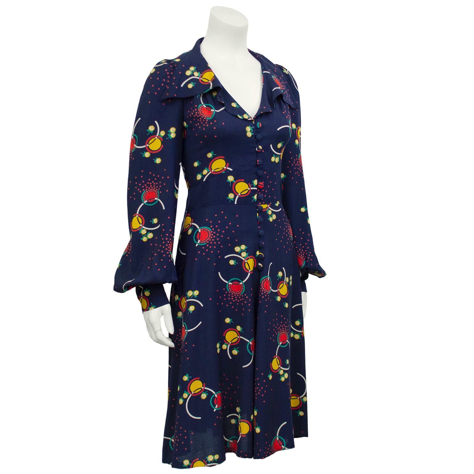 Amazing Bus Stop by Lee Bender day dress. Rayon navy blue with a fun abstract floral print in yellow, red, white and green. Oversized. loose lapels create a slight ruffle effect. V neckline and bishop sleeves. Covered buttons down centre and loose