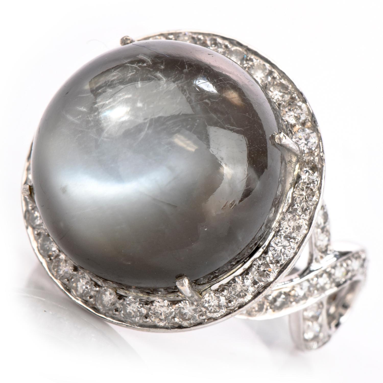 Questo opulento anello da cocktail Estate large, realizzato in oro bianco 18 carati, presenta un design a raggiera con gambo a motivo dell'infinito. L'anello cocktail è centrato da una pietra di luna rotonda cabochon e circondato da un'aureola di