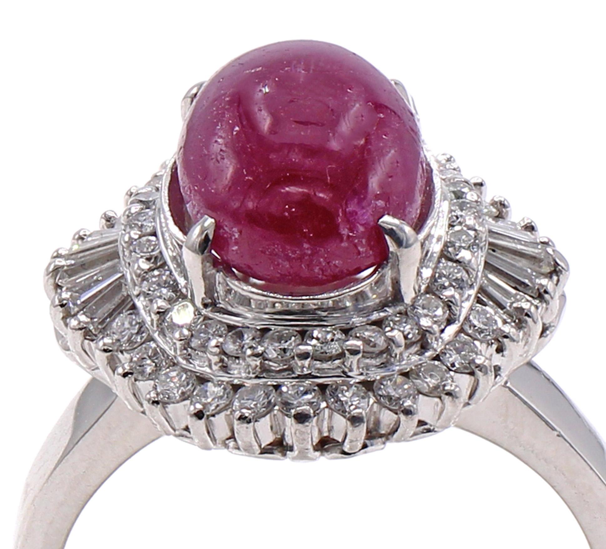 An elongated cabochon ruby weighing approximately 3.80 carats is the center piece of this 1960s ballerina ring. Mounted in platinum with the gallery embellished by bright white and sparkly round brilliant cut and baguette cut diamonds the ring