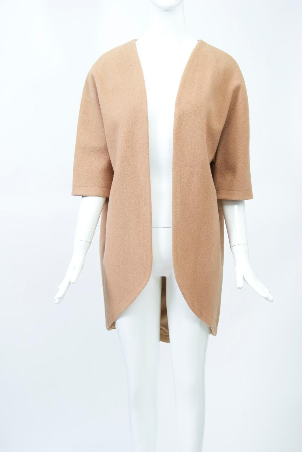 Camelhair blend cutaway jacket/coat with elbow-length dolman sleeves, collarless, and open front. Tan lining to match. The fabric was called Camapile, a blend of 85% wool and 15% camelhair. Minimalist and versatile mid-century piece to wear with a
