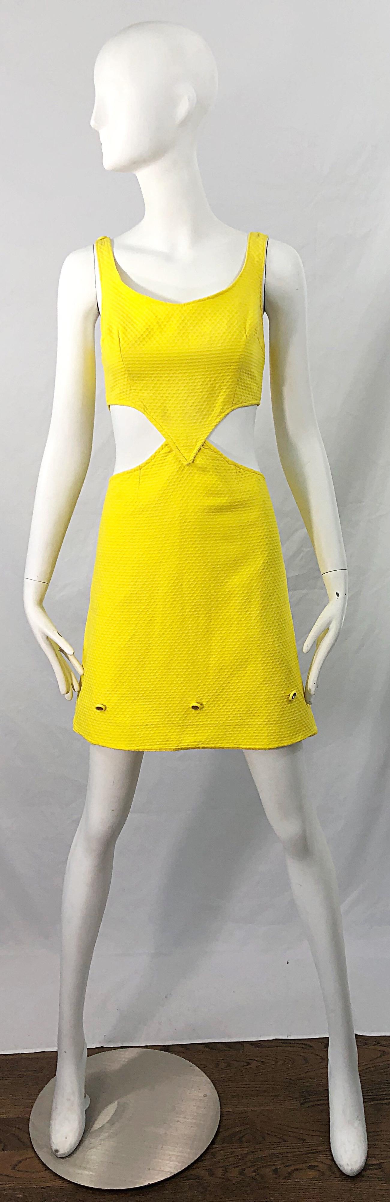 Chic 1960s canary yellow honeycomb pique cotton cut-out A Line dress ! Features cut-outs at each side of the waist. Adjustable gold glitter buttons at each shoulder to adjust length. Three of the same gold buttons along the front bottom of the