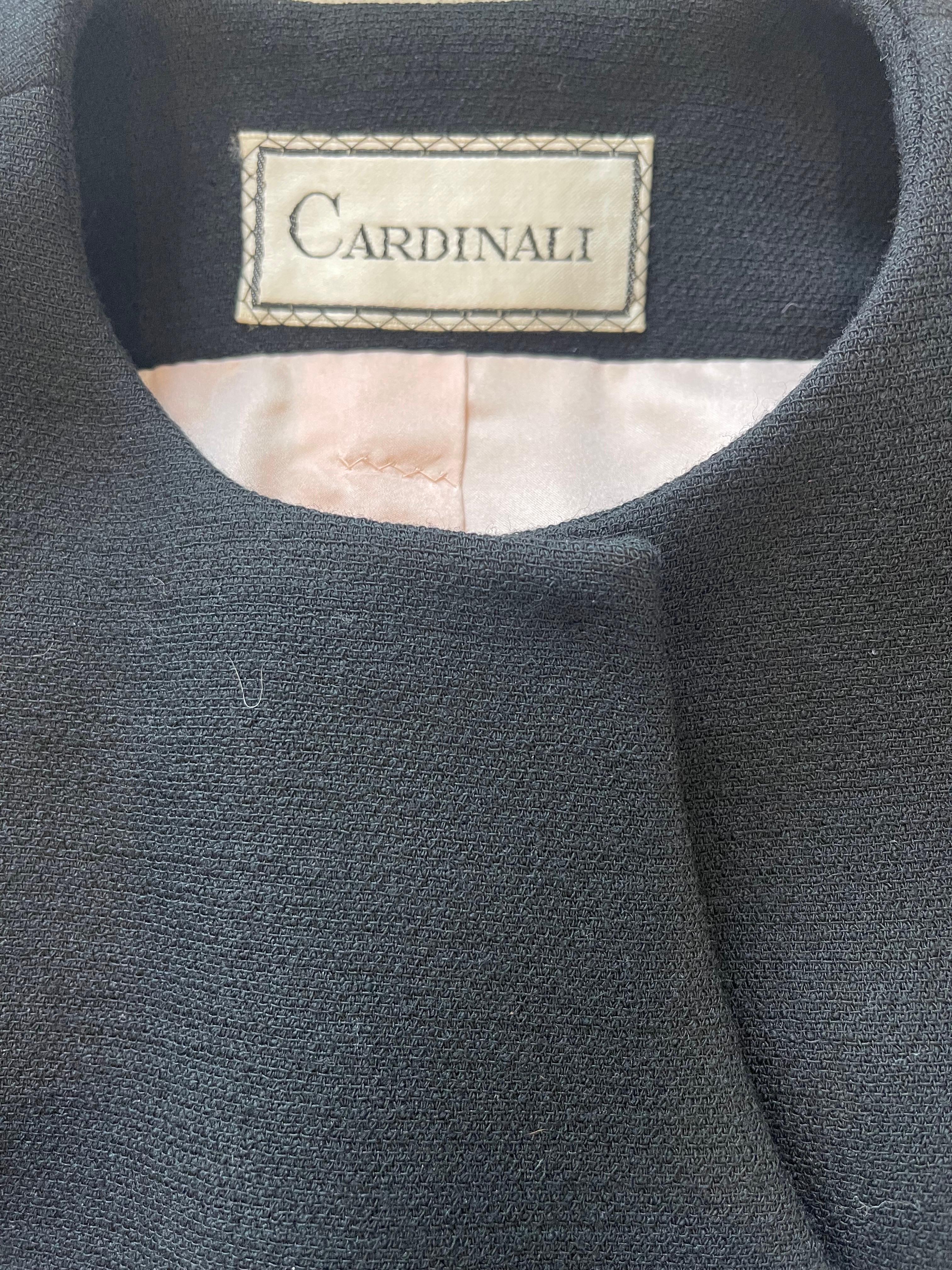 Chic vintage 60s Cardinali Couture black wool skirt suit ! Sleek tailored jacket features a unique asymmetrical closure with heavy duty hidden snaps. Beautiful light pink silk lining. Skirt has a flattering A-Line shape with hidden metal zipper up