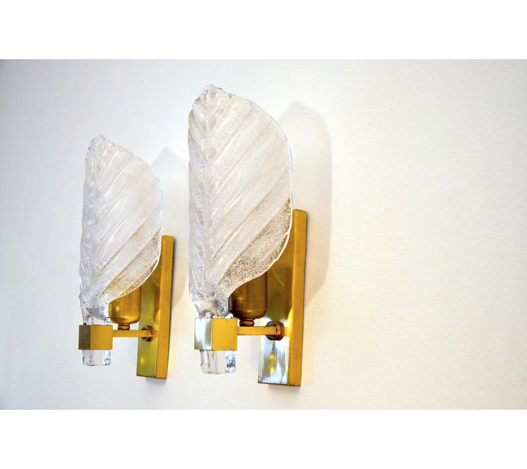 Pairs of sconces by Carl Fagerlund for Lyfa dating from the 1960s. The pair of sconces are made of brass and leaf-shaped glass. The diffused light is soft and harmonious, perfect to illuminate your interior. Time mark according to the age of the