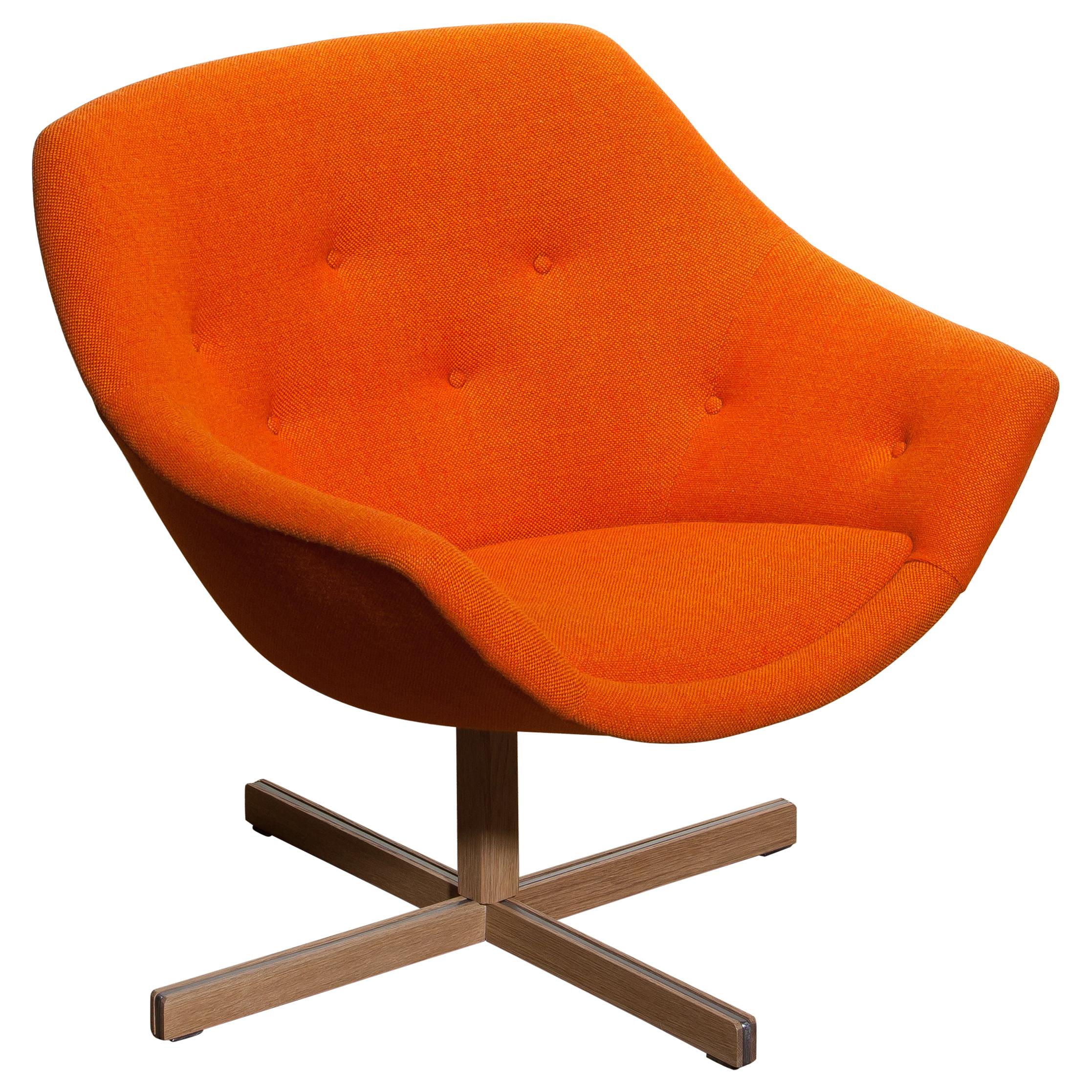 Extremely rare Mandarini swivel chair made by Carl Gustaf Hiort for Puunveisto Oy, wood work Ltd. This chair is upholstered with a buttoned orange fabric 'Hallingdal' by Kvadrat designed by Nanna Ditzel on an oak swivel base.
It is in very good