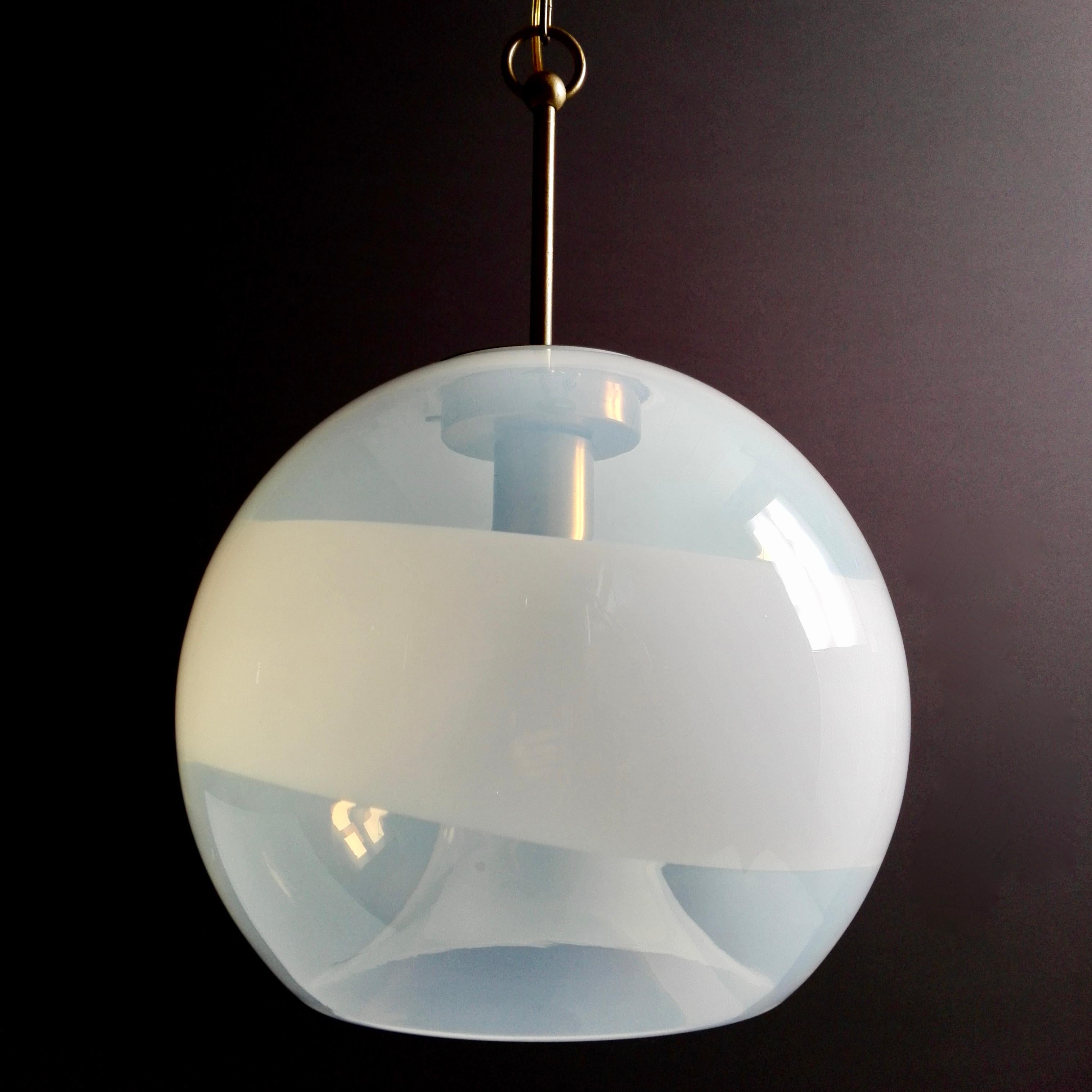 Rare Italian 60s one-light pendant lamp designed by Carlo Nason for Mazzega Murano.
The shade is opalescent with a light blue hue, it has been shaped to accommodate the lamp holder in a recess of the glass at the base of the sphere and attached to