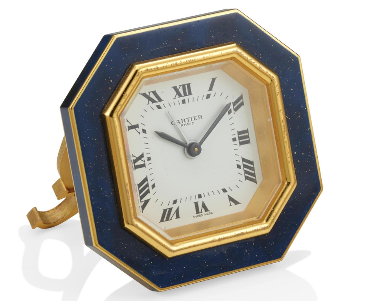 Eine blaue Cartier-Emaille-Uhr mit achteckigem Zifferblatt, römischen Ziffern und Handaufzug. Ein doppeltes C-Logo befindet sich auf dem Sockel der Uhr. 
Hergestellt in Paris, um 1960.