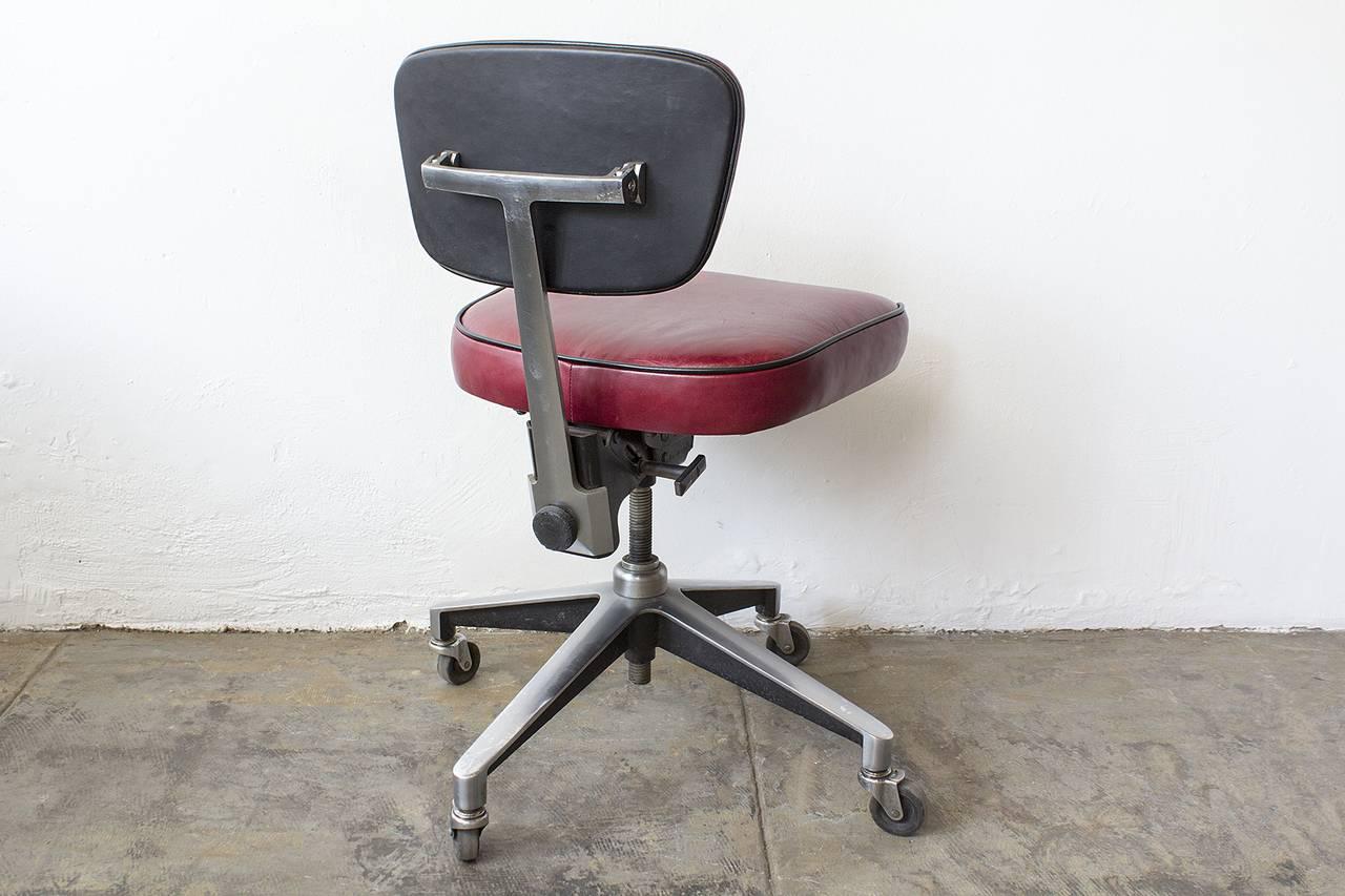 Retro industrial steno chair refinished in cherry red leather with black vinyl piping. This classic 1960s piece is especially unique for it's cast aluminum base. Swivels, rolls and adjusts.

30.5