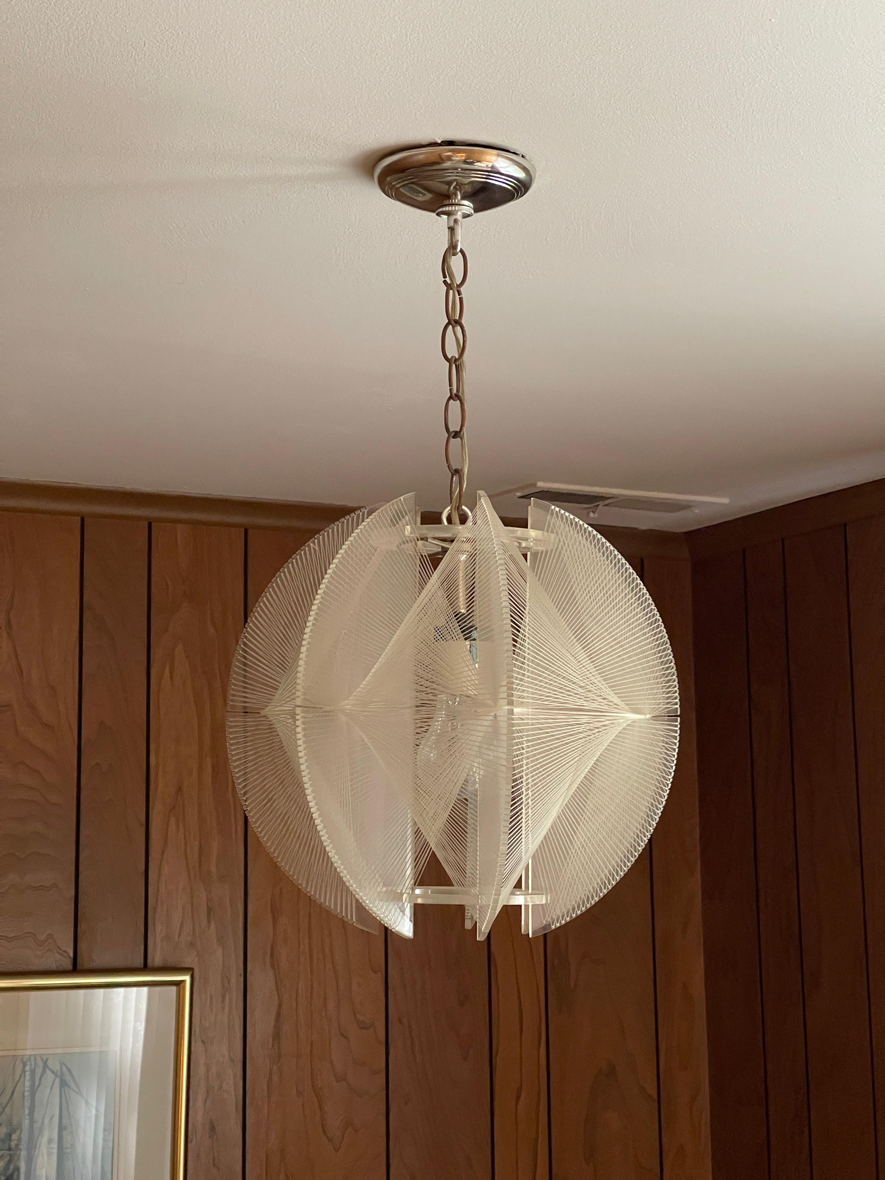 1960s ceiling lamp by Paul Secon for Sompex

A beautiful ceiling lamp from the 60s, designed for Sompex by Paul Secon. The lamp has a clear lucite frame with threaded nylon filament plus chrome fixings. A perfect use of shape and materials for a