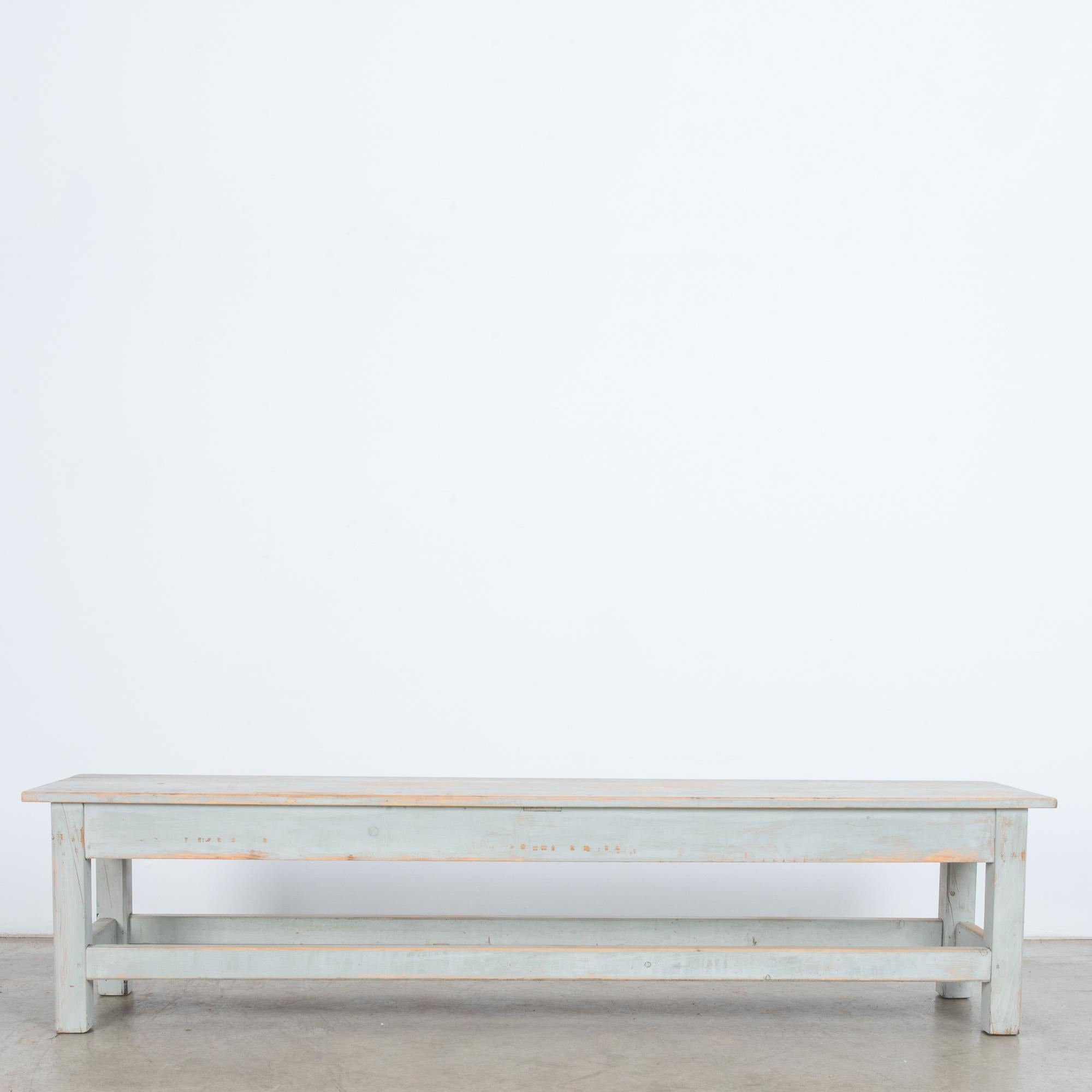 This wooden bench was made in Central Europe, circa 1960. The rectangular seat, four angular legs, and stretchers on all sides construct its geometric form. The natural wood and grain pattern is visible beneath the time-worn patina of the dusky blue