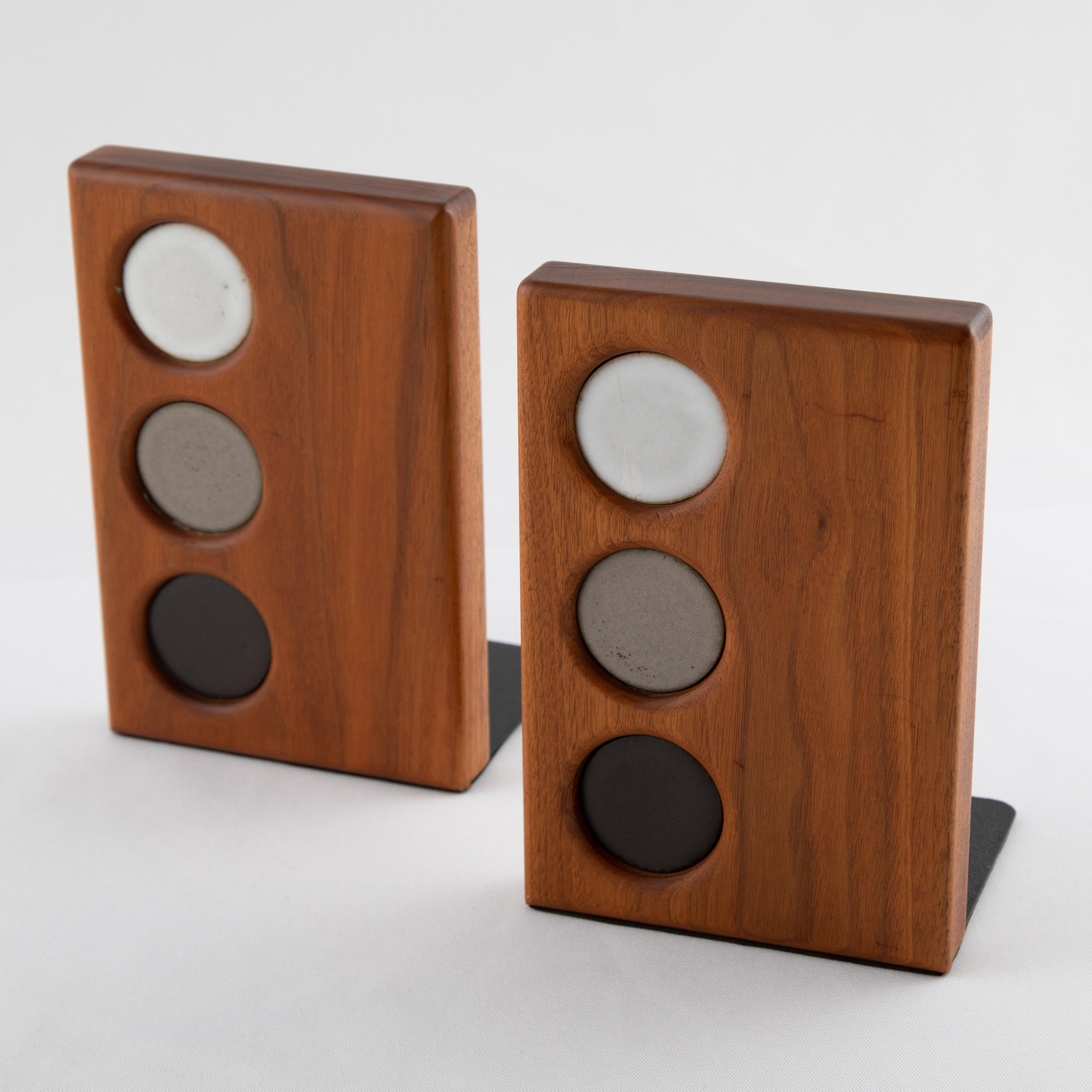 Pair of walnut bookends with inset circular ceramic tiles in white, gray and black, by Jane and Gordon Martz for Marshall Studios. Original Marshall Studios Inc. sticker on base of one bookend.


