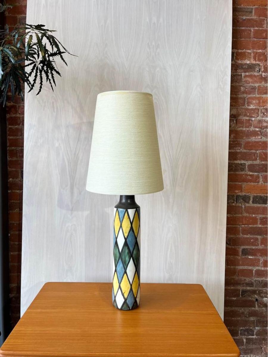 Wir sind begeistert, diese exquisite handbemalte Keramik-Tischlampe aus den 1960er Jahren von Lotte und Gunnar Bostland anbieten zu können. Mit einem originalen, von den Künstlern selbst handbemalten Glasfaserschirm, der ein harmonisches Kreuzmuster