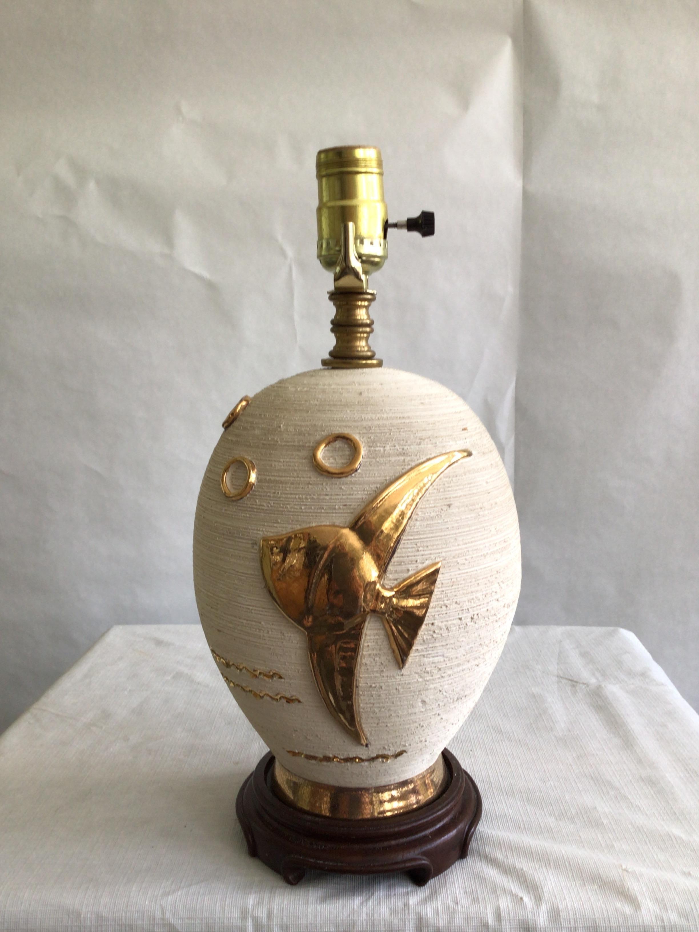 1960s Ceramic Pottery Lamp With Fish Appliqué On Wooden Base
Rough Cream Texture with shiny and smooth Gold Appliqué of a fish and bubbles
Height to Top of Socket
Needs Rewiring
